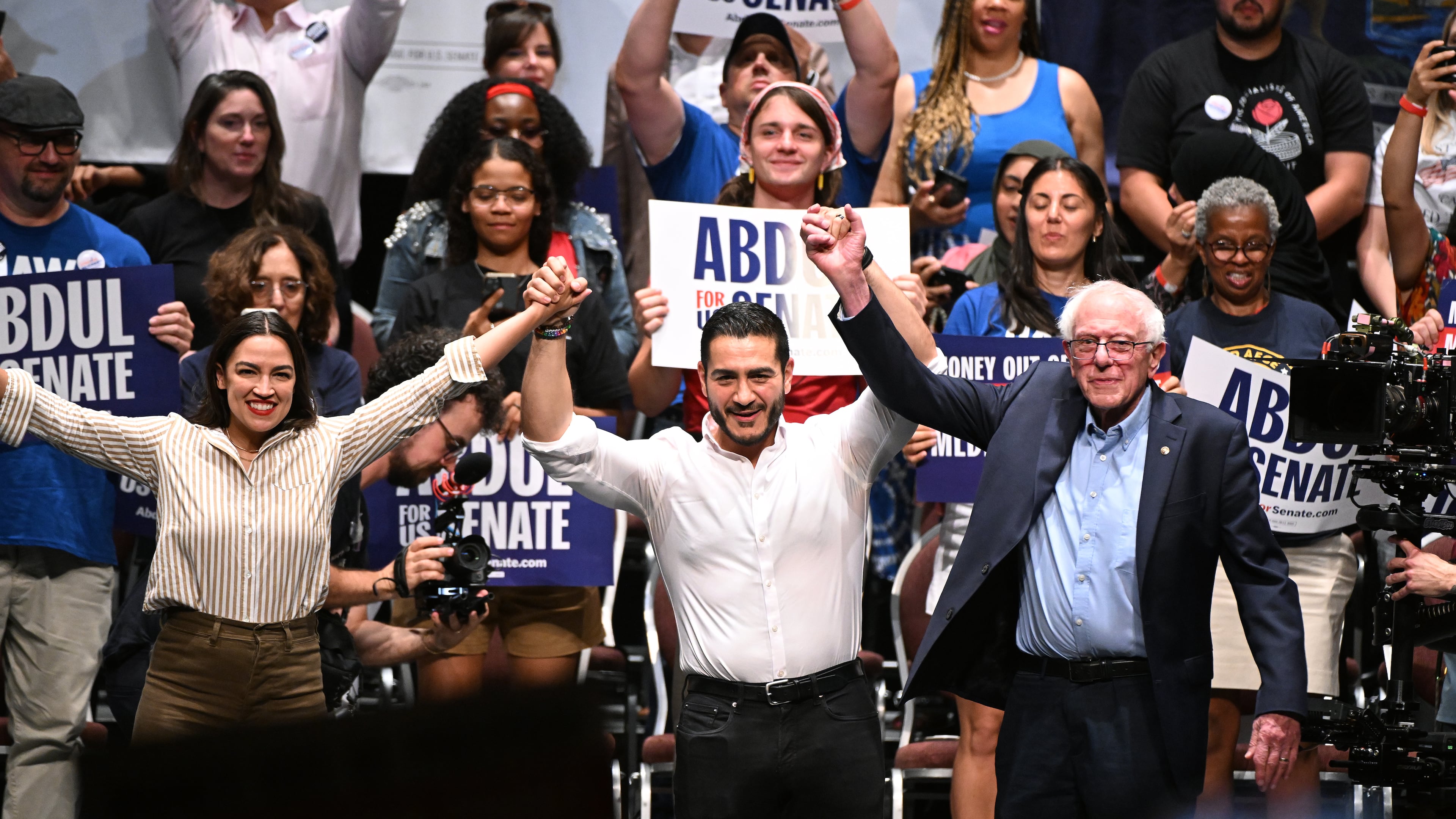 From left foreground, U.S. Rep. Alexandria Ocasio-Cortez, D-N.Y., Michigan Democratic U.S. Senate primary candidate Abdul El-Sayed, and U.S. Sen. Bernie Sanders, I-VT. join hands together following a campaign rally, Saturday, July 18, 2026, in Detroit. (AP Photo/Jose Juarez)