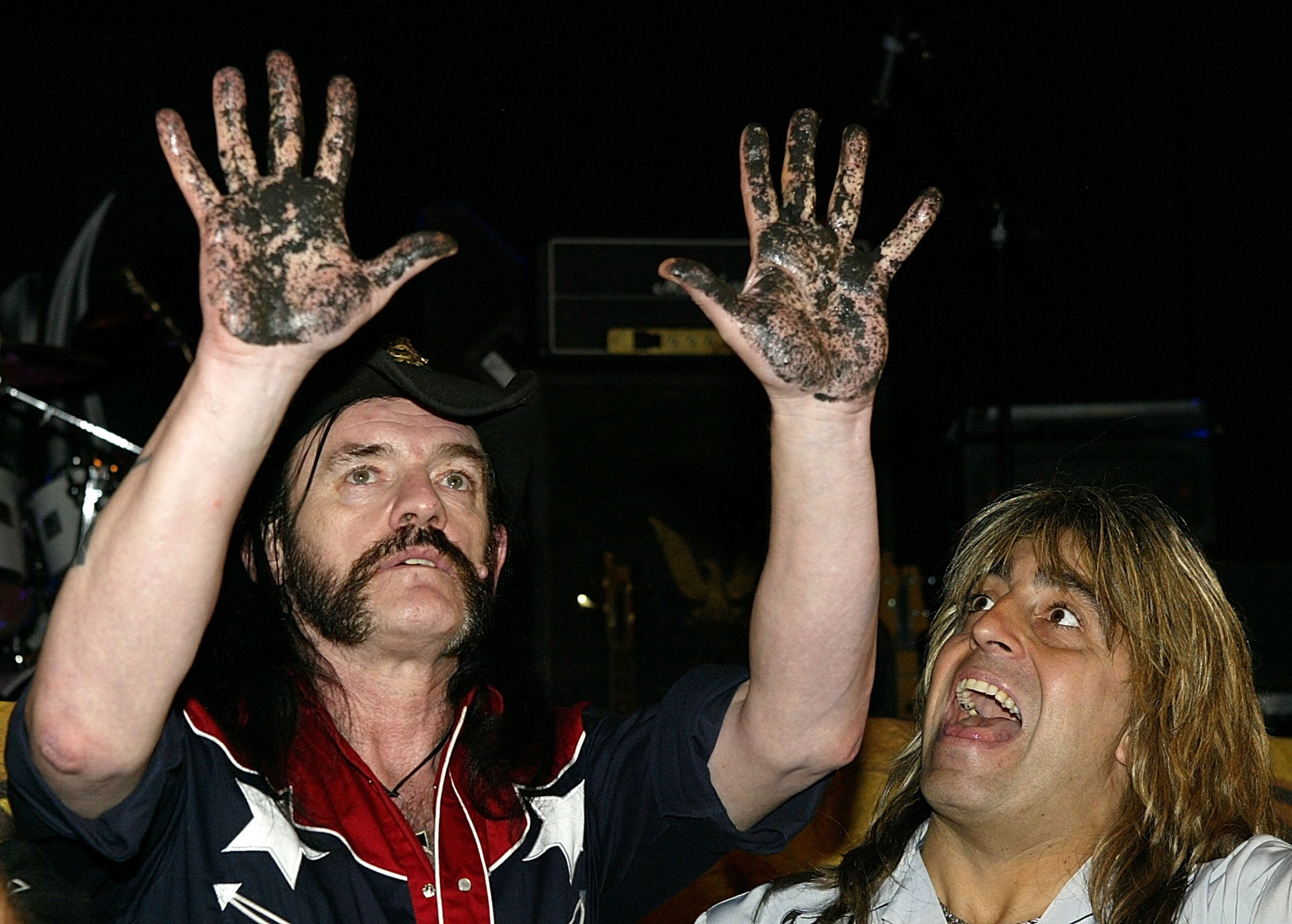 HOLLYWOOD - SEPTEMBER 1: Motorhead lead singer Lemmy Kilmister (L) holds up his hands after he pressed them into concrete as Mikkey Dee laughs during their induction into Hollywood's RockWalk at the Whisky A Go-Go September 1, 2003 in Hollywood, California. The band will be performing tonight at the legendary club. (Photo by Carlo Allegri/Getty Images)