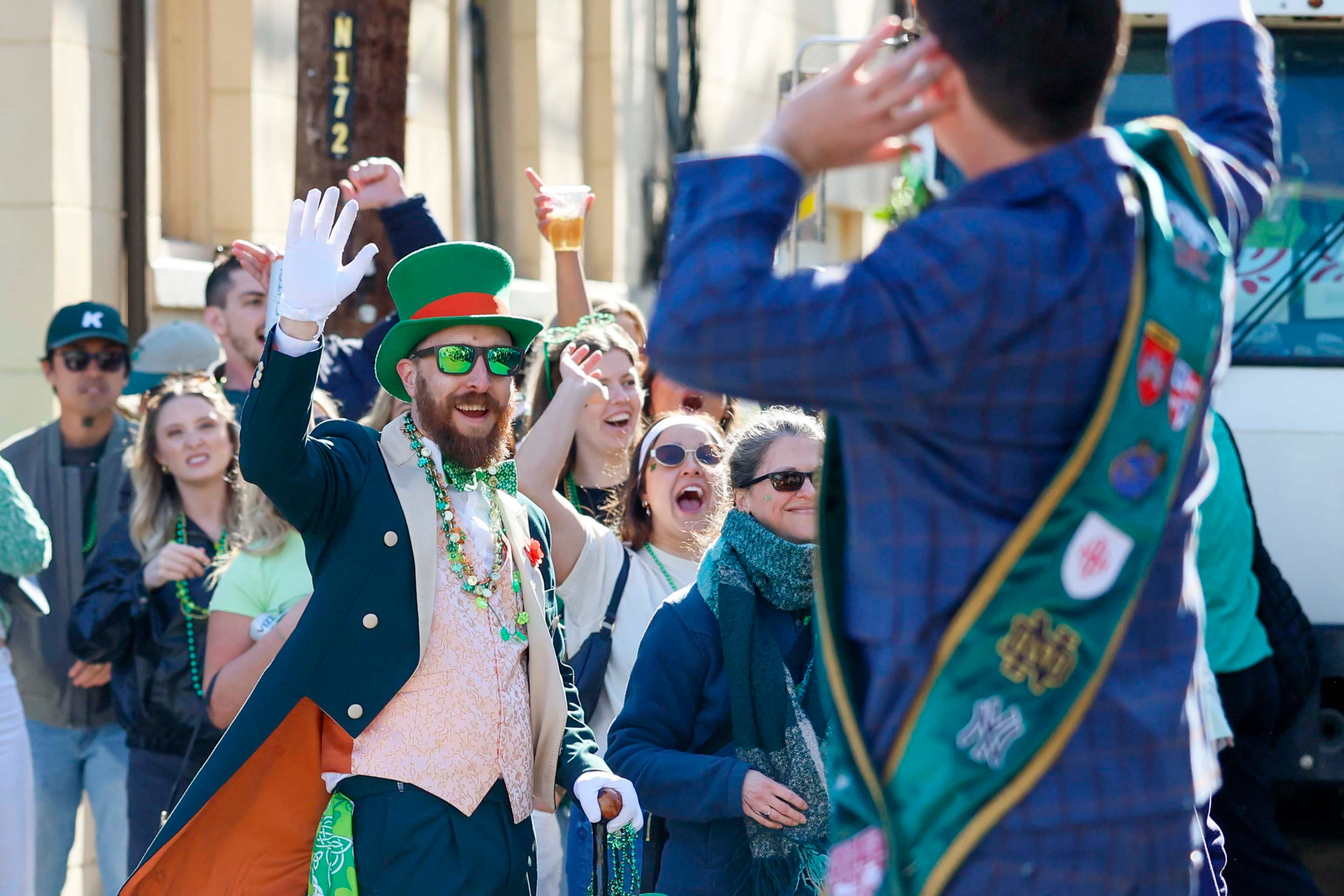 Spectators wave to parade participants during the St. Patrick’s Day celebration in Savannah on Tuesday, March 17, 2026. (Miguel Martinez/AJC)
