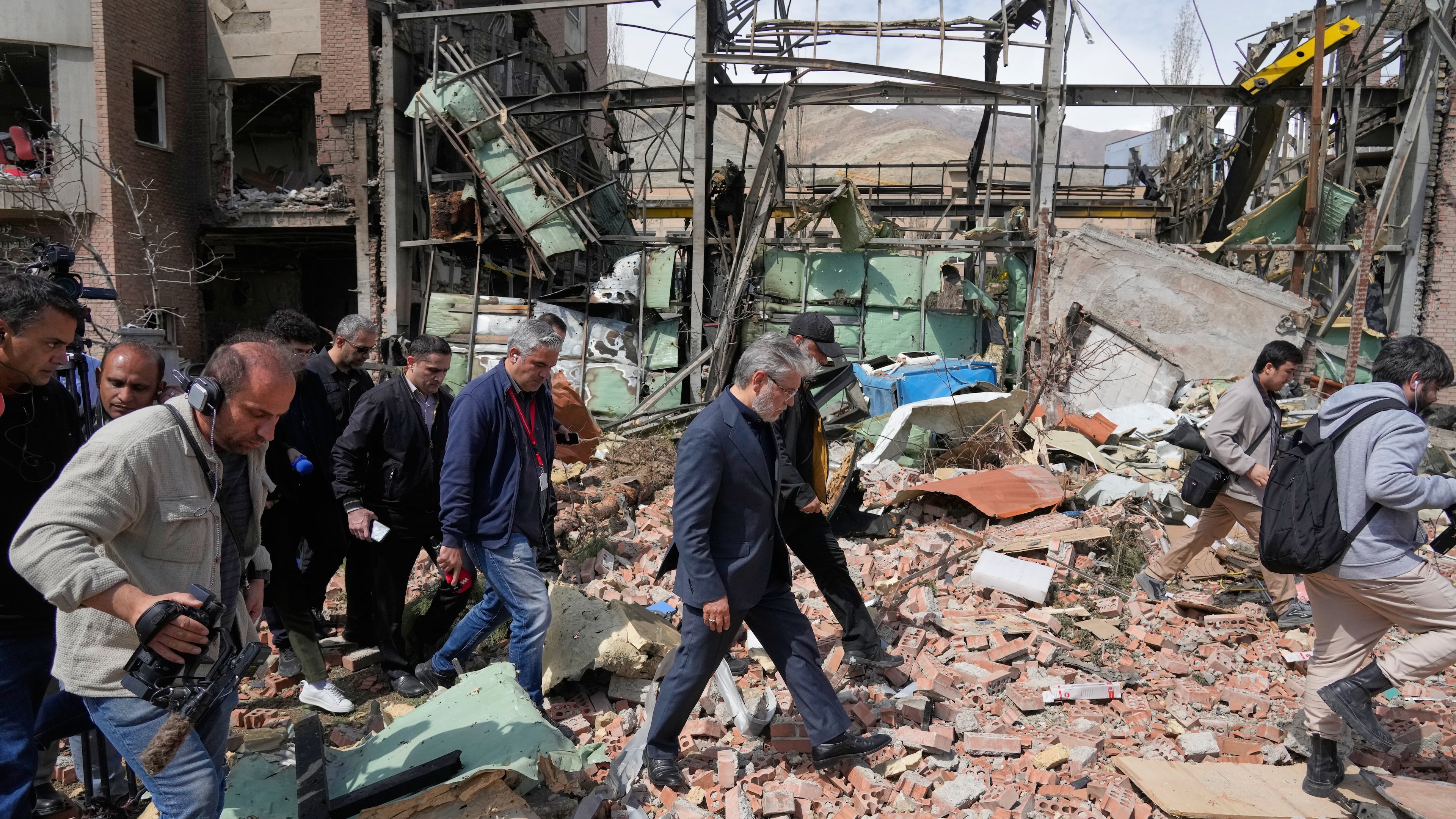 Iran's Minister of Science, Research and Technology Hossein Simaei Sarraf, center, visits the location that was hit during U.S.-Israeli airstrikes Friday at Shahid Beheshti University in Tehran, Iran, Saturday, April 4, 2026. (AP Photo/Vahid Salemi)