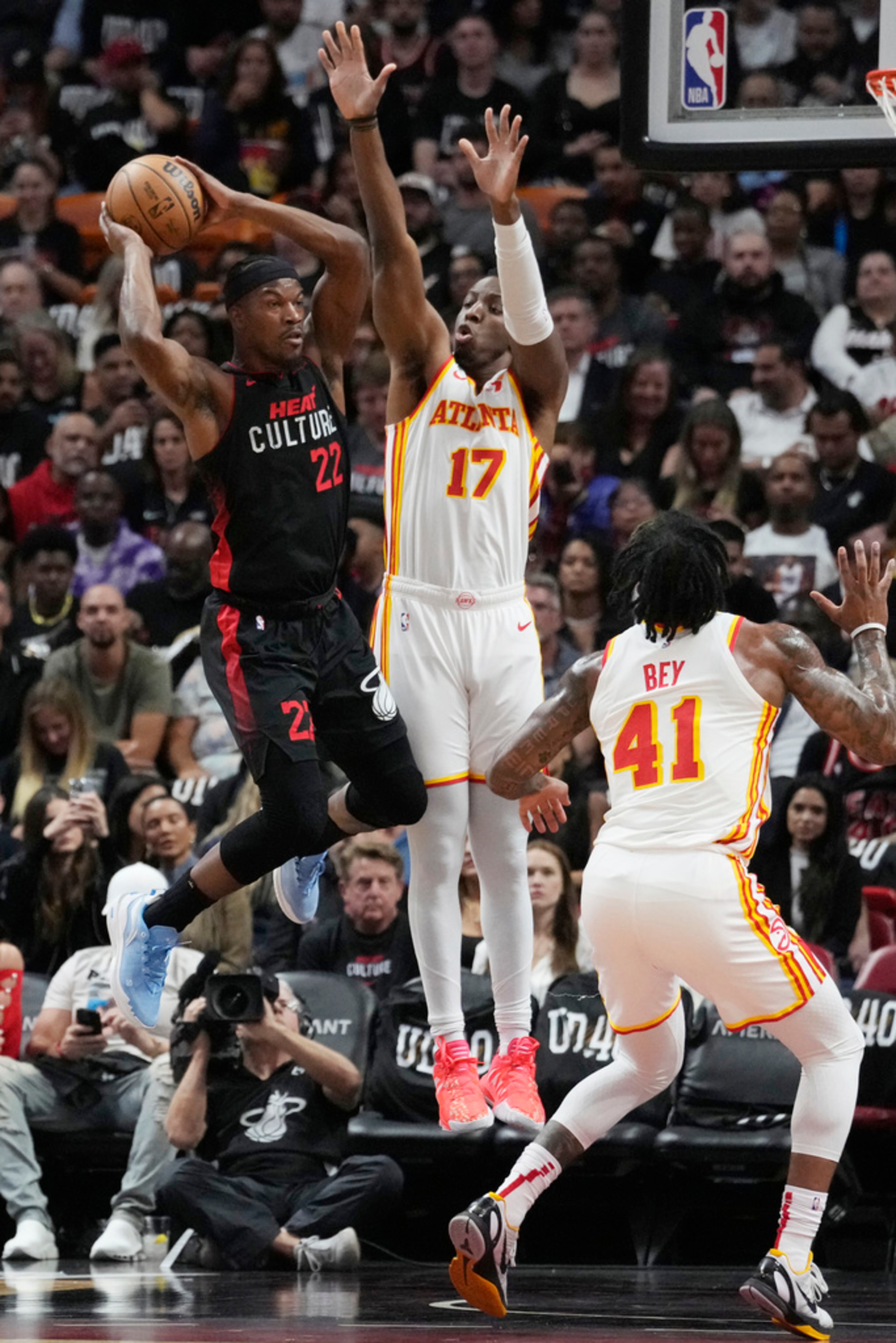 Miami Heat forward Jimmy Butler (22) looks to pass the ball as Atlanta Hawks forward Onyeka Okongwu (17) defends during the first half of an NBA basketball game, Friday, Jan. 19, 2024, in Miami. (AP Photo/Marta Lavandier)