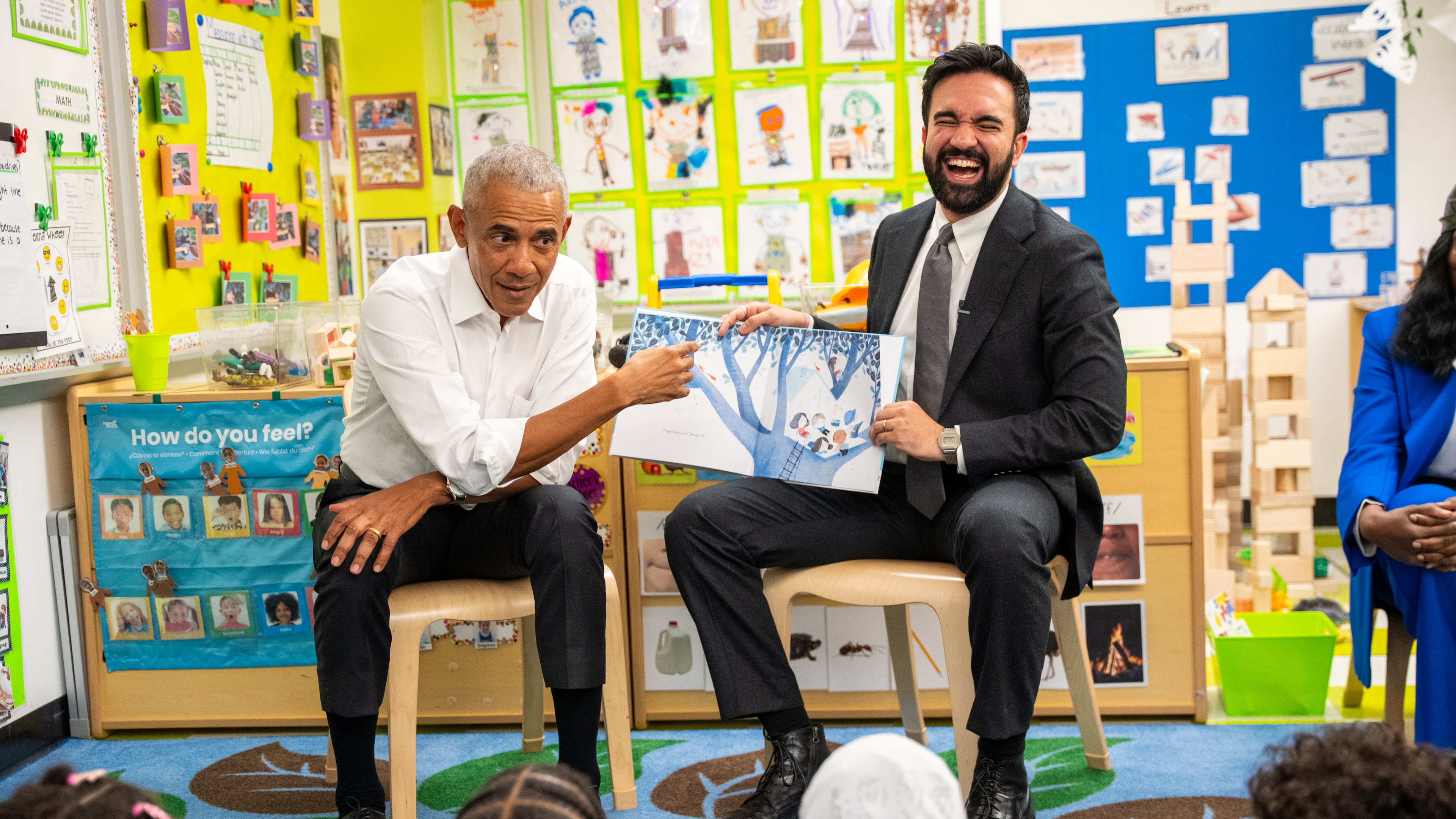 Former President Barack Obama, left, and Mayor Zohran Mamdani read a book to children at Learning Through Play Pre-K in New York, on Saturday, April 18, 2026. (AP Photo/Angelina Katsanis)