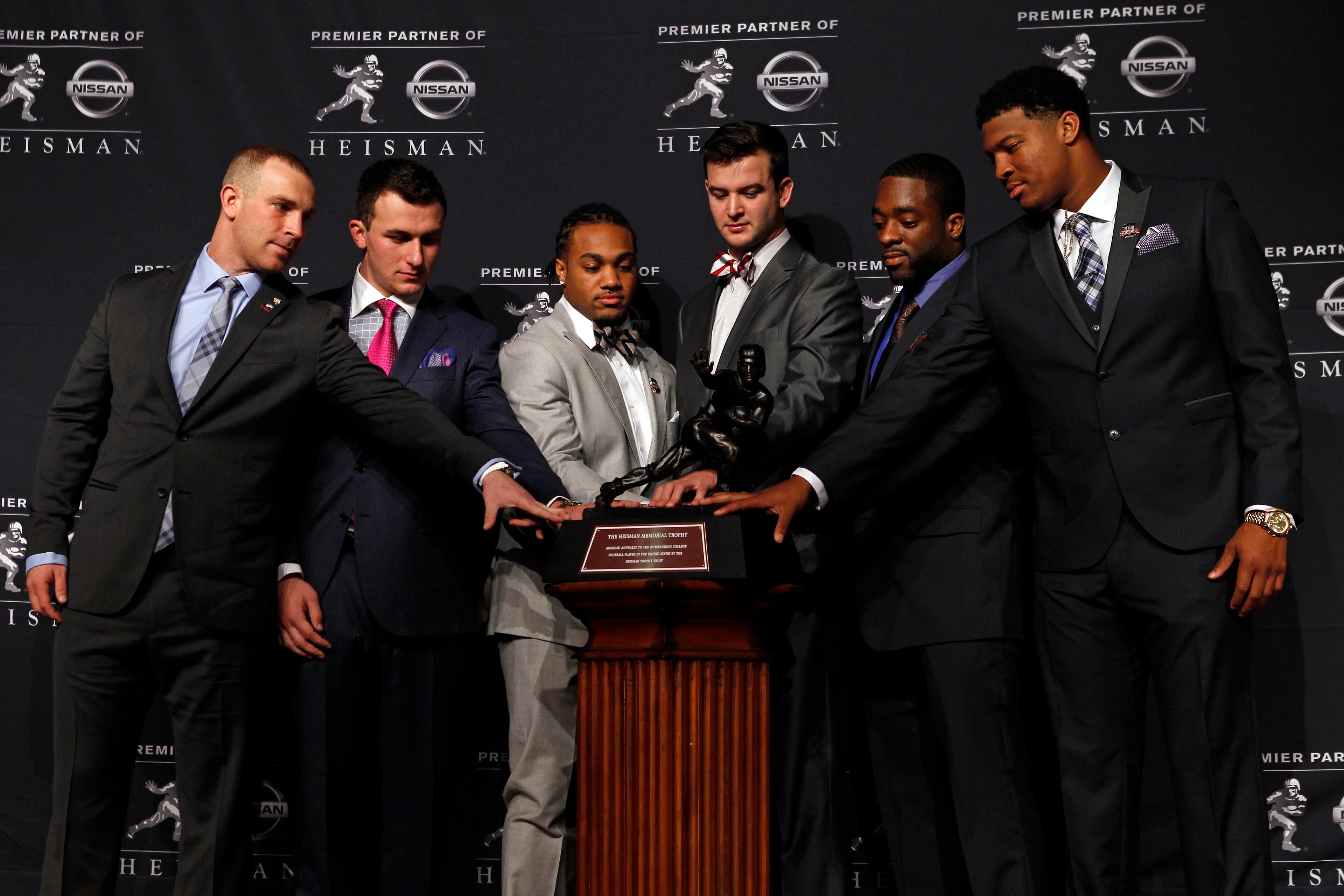 (From left to right) Northern Illinois Huskies quarterback Jordan Lynch, and Texas A&M Aggies quarterback Johnny Manziel, and Auburn Tigers running back Tre Mason, and Alabama Crimson Tide quarterback AJ McCarron, and Boston College Eagles running back Andre Williams and Florida State Seminoles quarterback Jameis Winston pose for a photo with the Heisman Trophy during a press conference before the announcement of the 2013 Heisman Trophy winner at the Marriott Marquis in New York City. Florida State Seminoles quarterback Jameis Winston won the award, becoming the youngest winner in Heisman history. Mandatory Credit: Adam Hunger-USA TODAY Sports