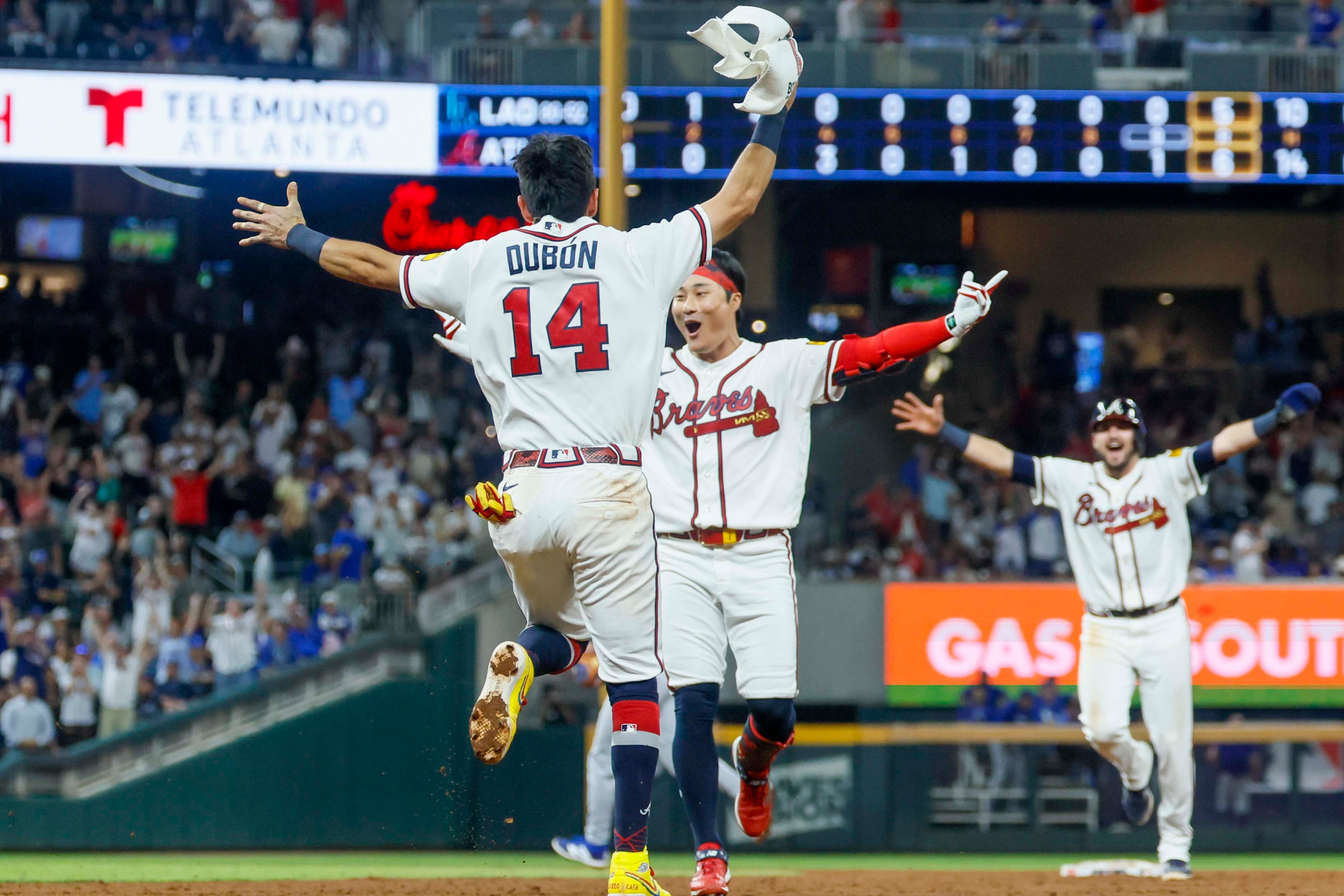 Atlanta Braves left fielder Mauricio Dubón (left center) runs to celebrate with Braves shortstop Ha-Seong Kim (center) after hitting a walk-off single in the ninth inning against the Los Angeles Dodgers at Truist Park in Atlanta on Wednesday, Aug. 26, 2026. The Braves defeated the Dodgers 6-5. (Miguel Martinez/AJC)