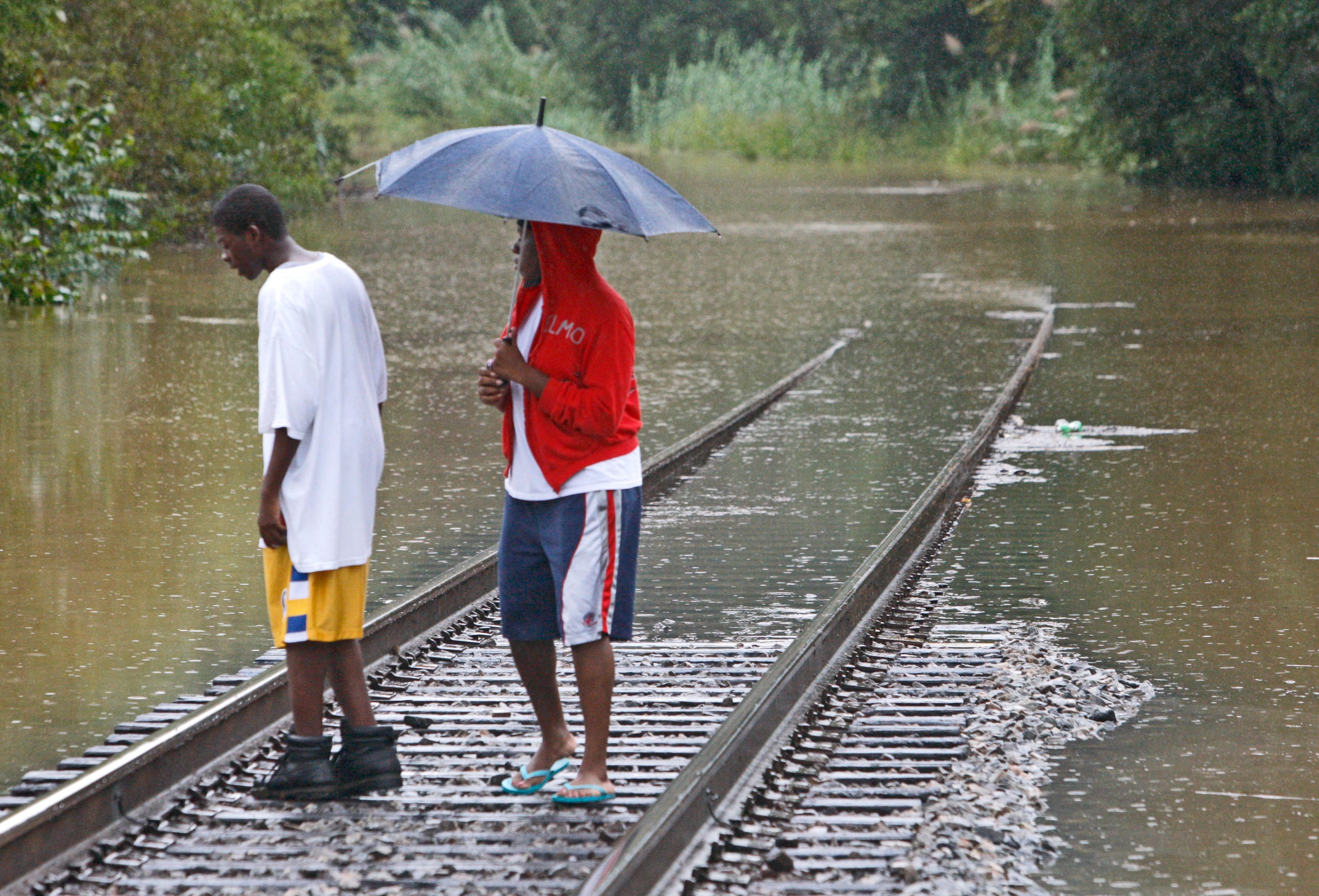 Malcom and Shantisha Johnson of Powder Springs check out the flooded railroad tracks that cross Marietta Road. Many roads were closed due to flooding on Monday, Sep. 21, 2009. (Photo: Bob Andres, bandres@ajc.com )