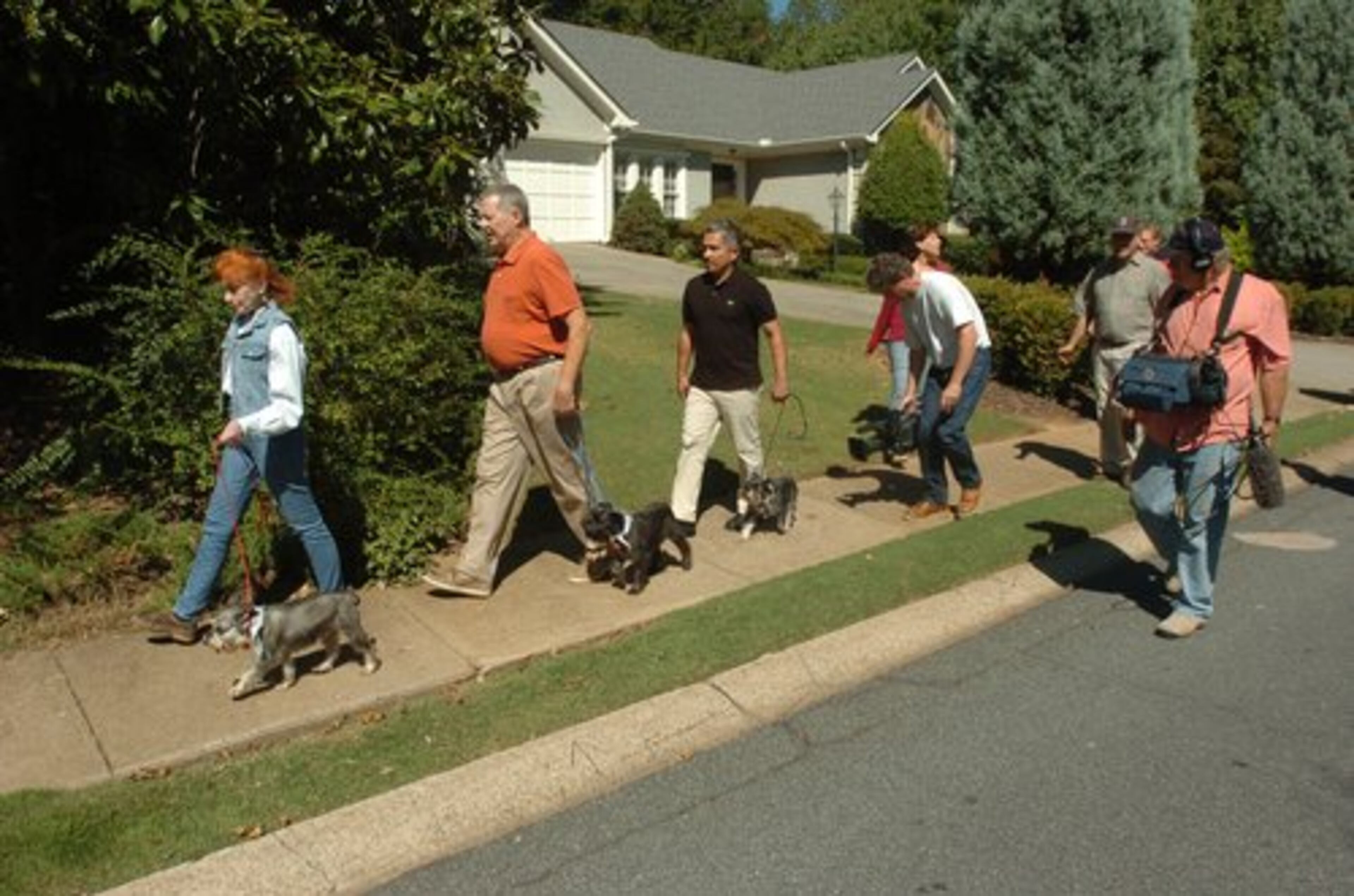 Marcia Sasser and husband Jim walk their dogs with "Dog Whisperer" Cesar Millan, as cameraman Chris Komives records their moves with "sound dog" Miles Ghormley. Millan urges people to make sure to walk their dogs. "Dogs need the stimulation of a walk, the time with their pack, the exercise," he said during his visit. "It's not the same just putting them in the yard."