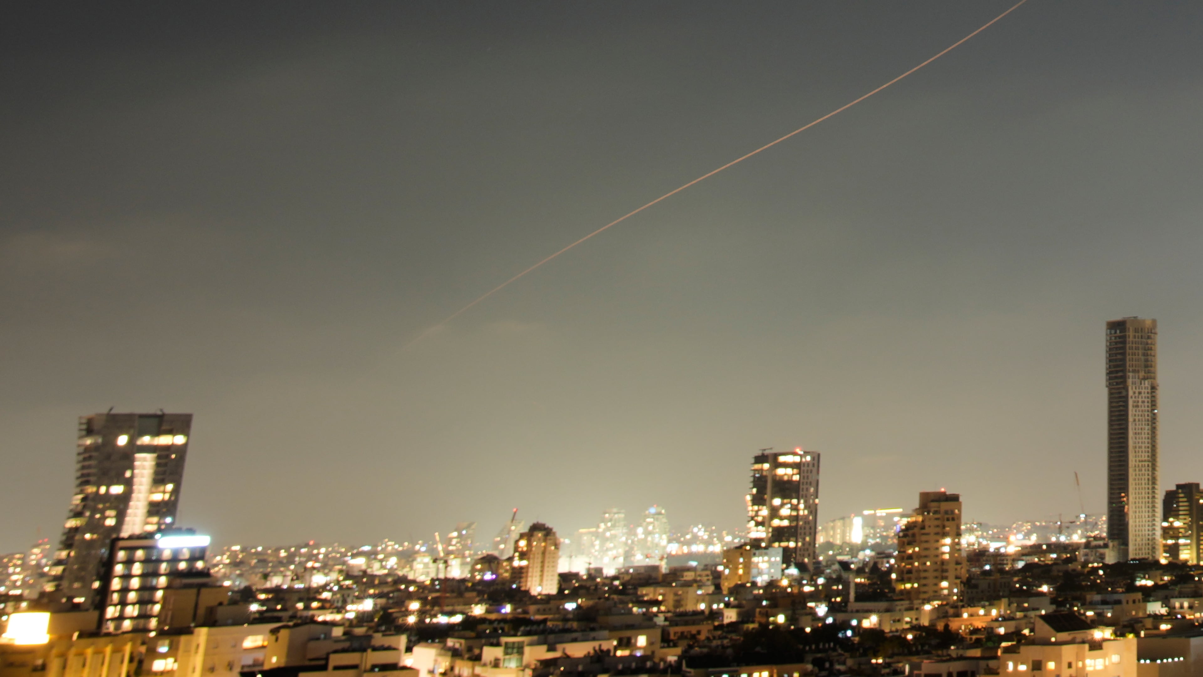 A projectile streaks through the sky over central Israel during an Iranian missile attack, Sunday, June 7, 2026. (AP Photo/Ohad Zwigenberg)