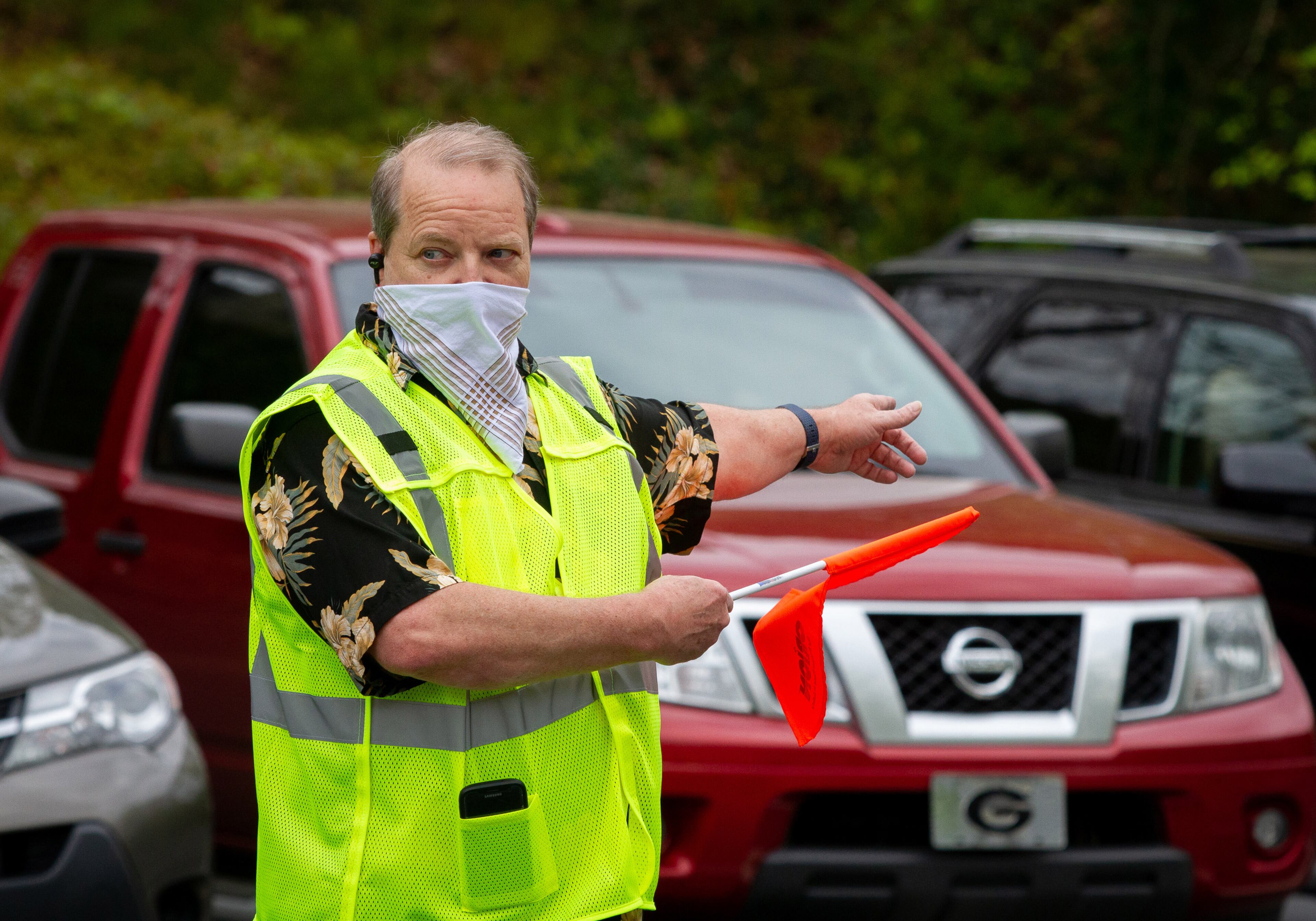 Richard Smith directs traffic before the beginning of the Drive-in church service at the Life Church Smyrna Assembly of God Sunday, April 5, 2020. STEVE SCHAEFER / SPECIAL TO THE AJC