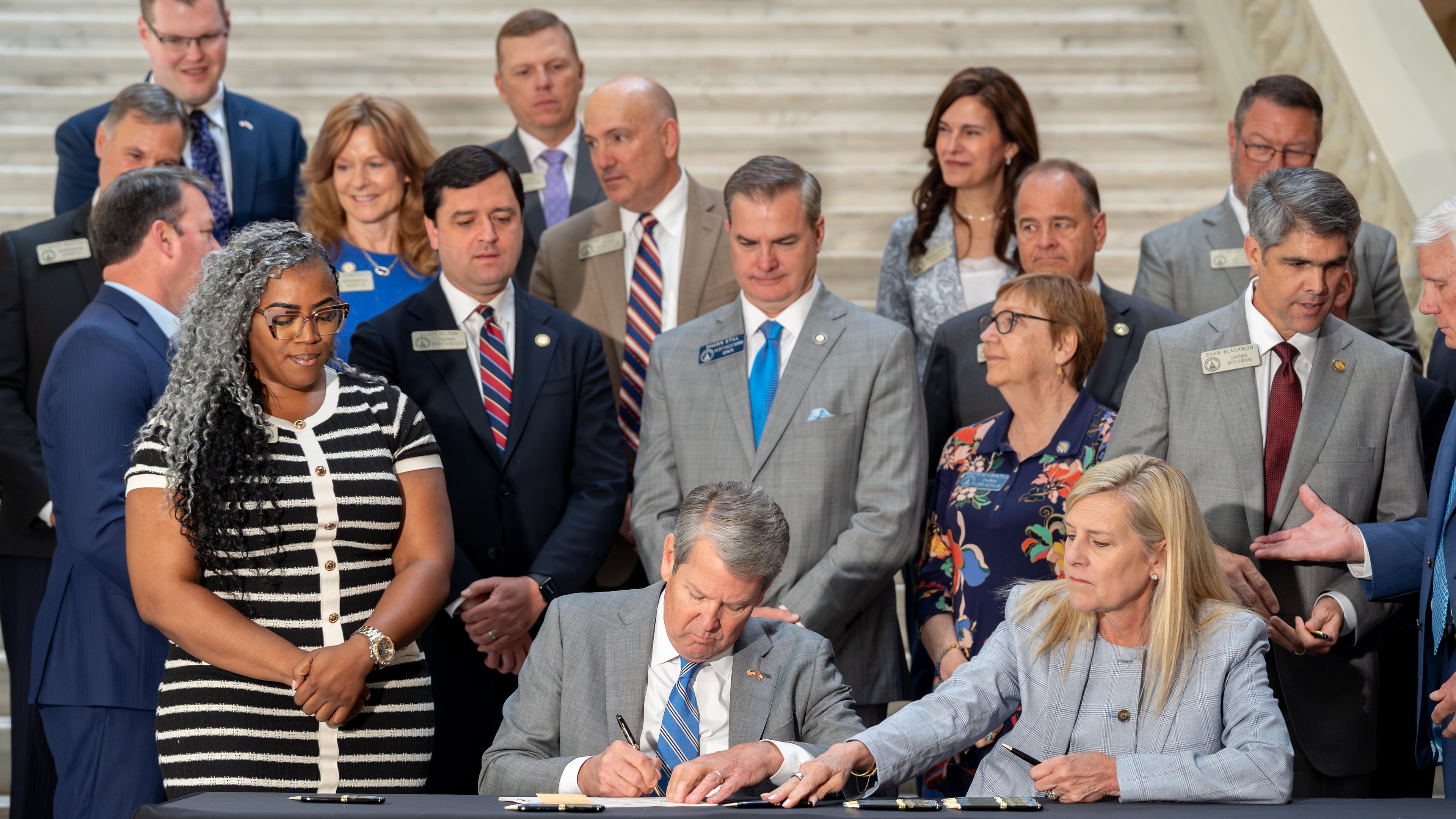 Gov. Brian Kemp signs House Bill 463 on Monday. The law cuts the state income tax rate. (Ben Hendren for the AJC)