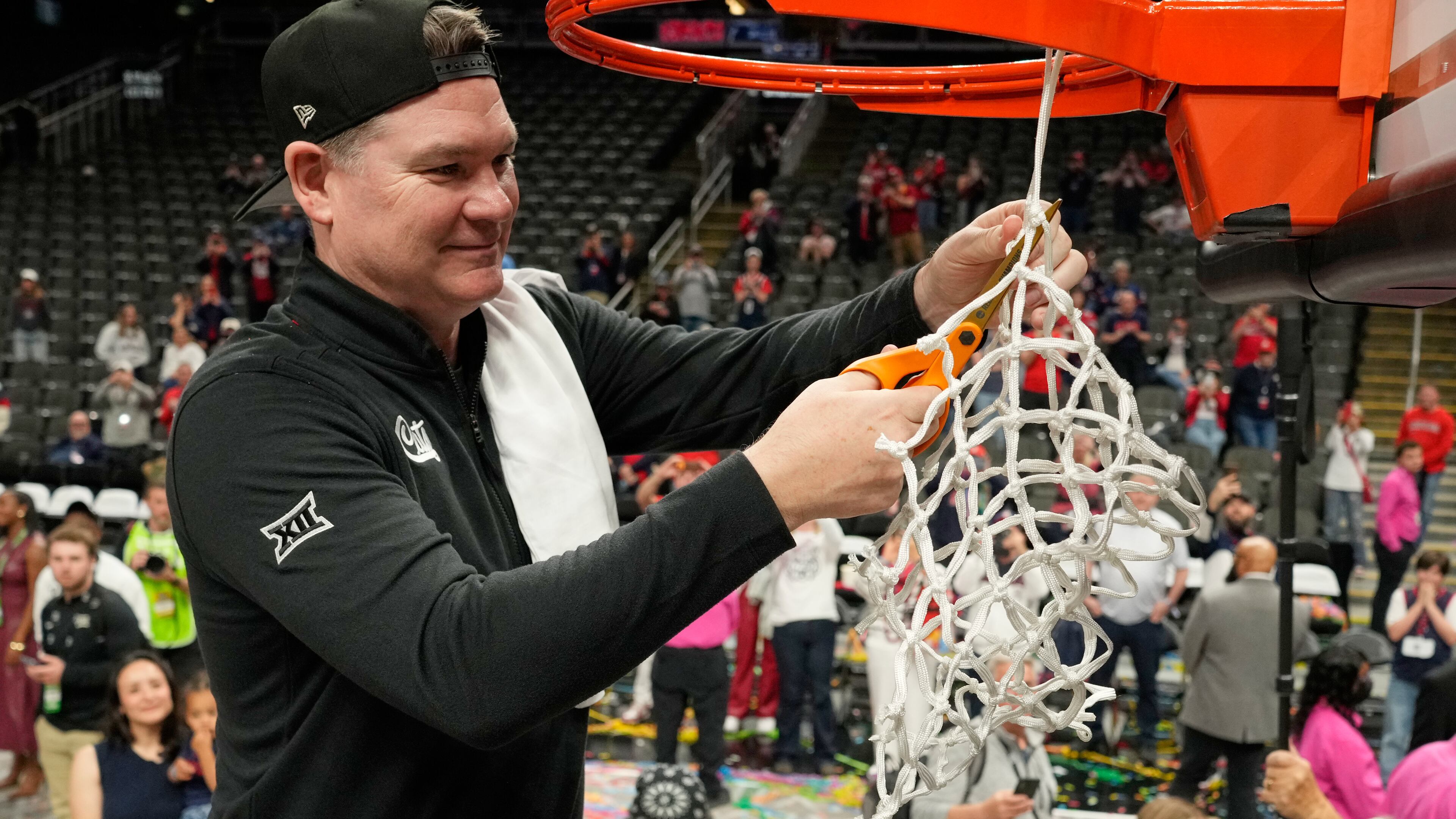 Arizona head coach Tommy Lloyd cuts down the net after winning an NCAA college championship basketball game at the Big 12 Conference tournament Saturday, March 14, 2026, in Kansas City, Mo. (AP Photo/Charlie Riedel)