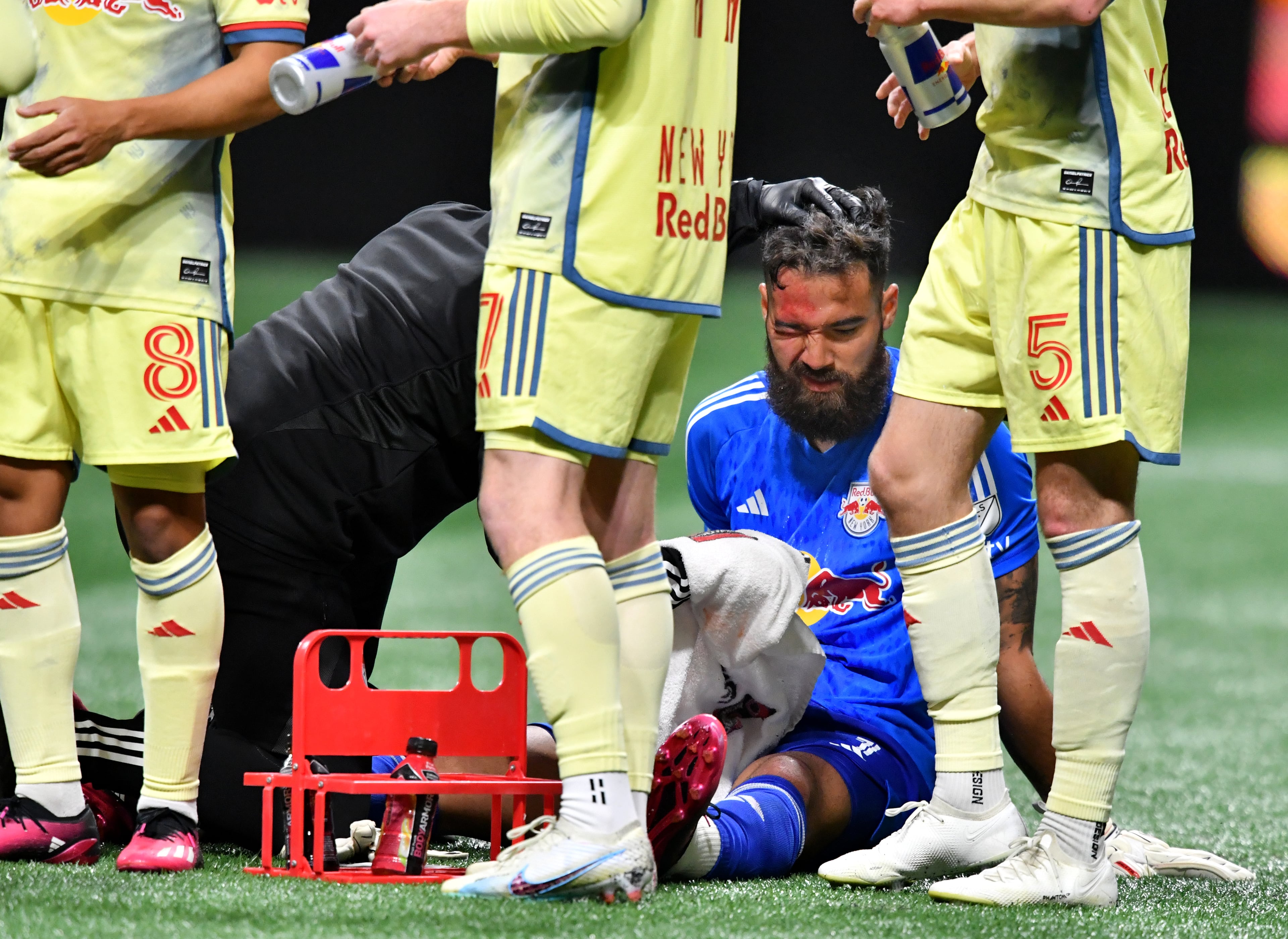New York Red Bulls' goalkeeper Carlos Miguel Coronel (1) is treated after he collied with Atlanta United's midfielder Thiago Almada. (Hyosub Shin / Hyosub.Shin@ajc.com)