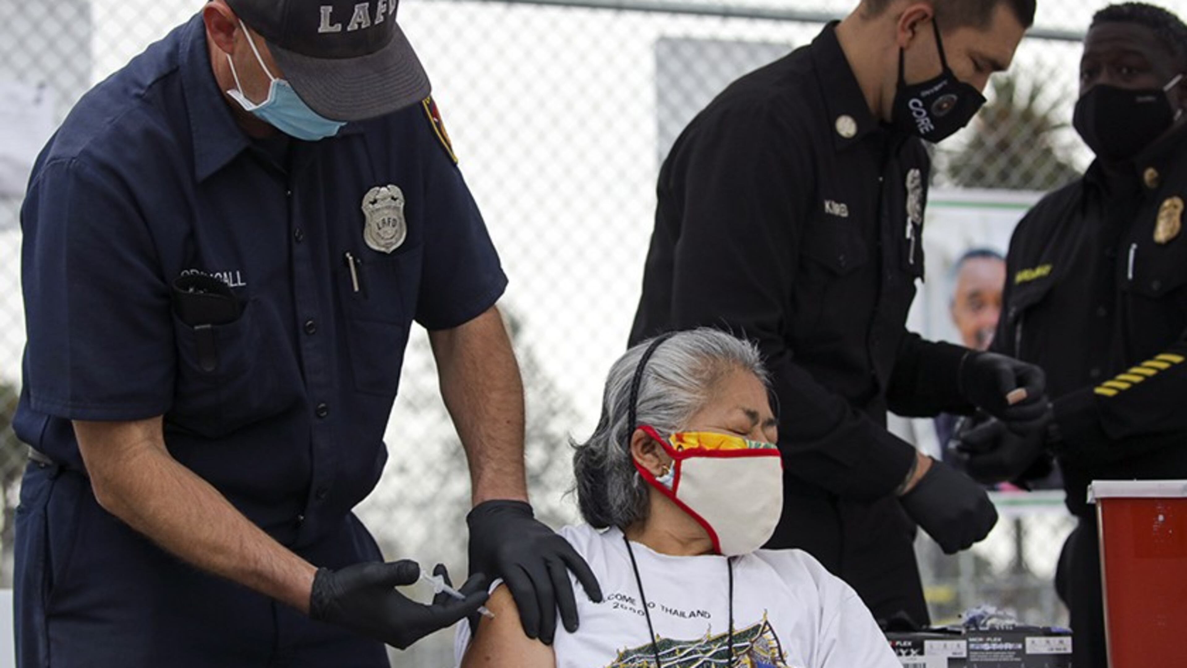 Firefighter Anthony MacDougall administers a COVID-19 vaccine to Carmen Limeta at a mobile vaccination site at South Park Recreation Center in Los Angeles. In Sandy Springs, a mobile vaccine site operated by Community Organized Relief Effort has opened. (Irfan Khan/Los Angeles Times/TNS)