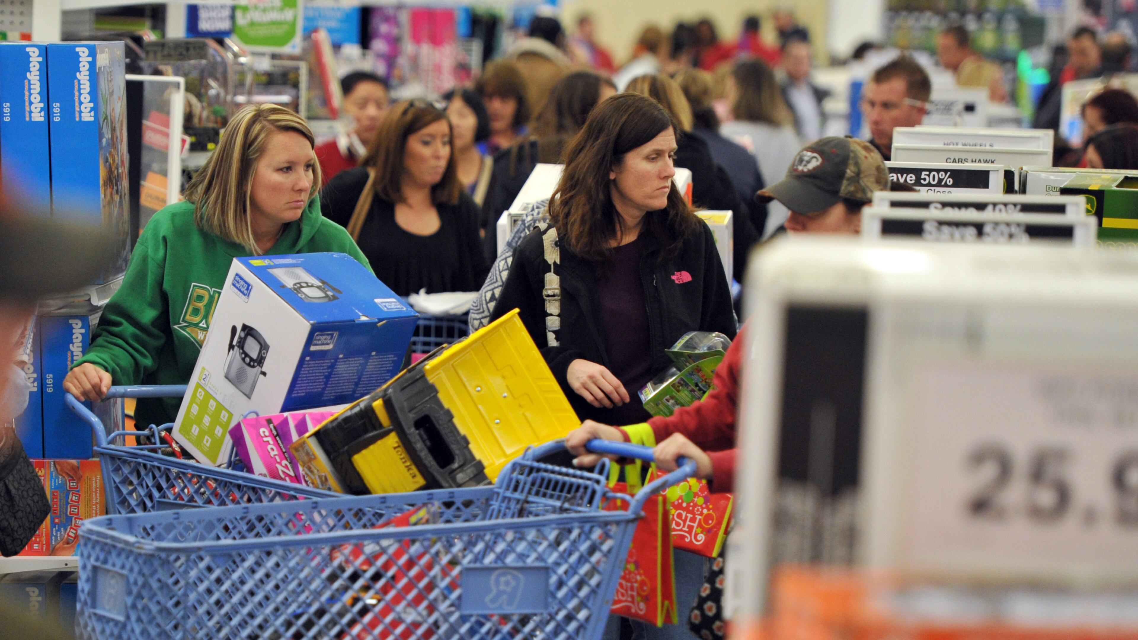 Jennifer Elinburg (left), of Buford, pushes her cart thru the store to shop for her son at the Toys R Us store on Financial Center Way in Buford on Thursday, November 81, 2013. This year, Black Friday starts earlier, with some retailers opening early on Thanksgiving evening.