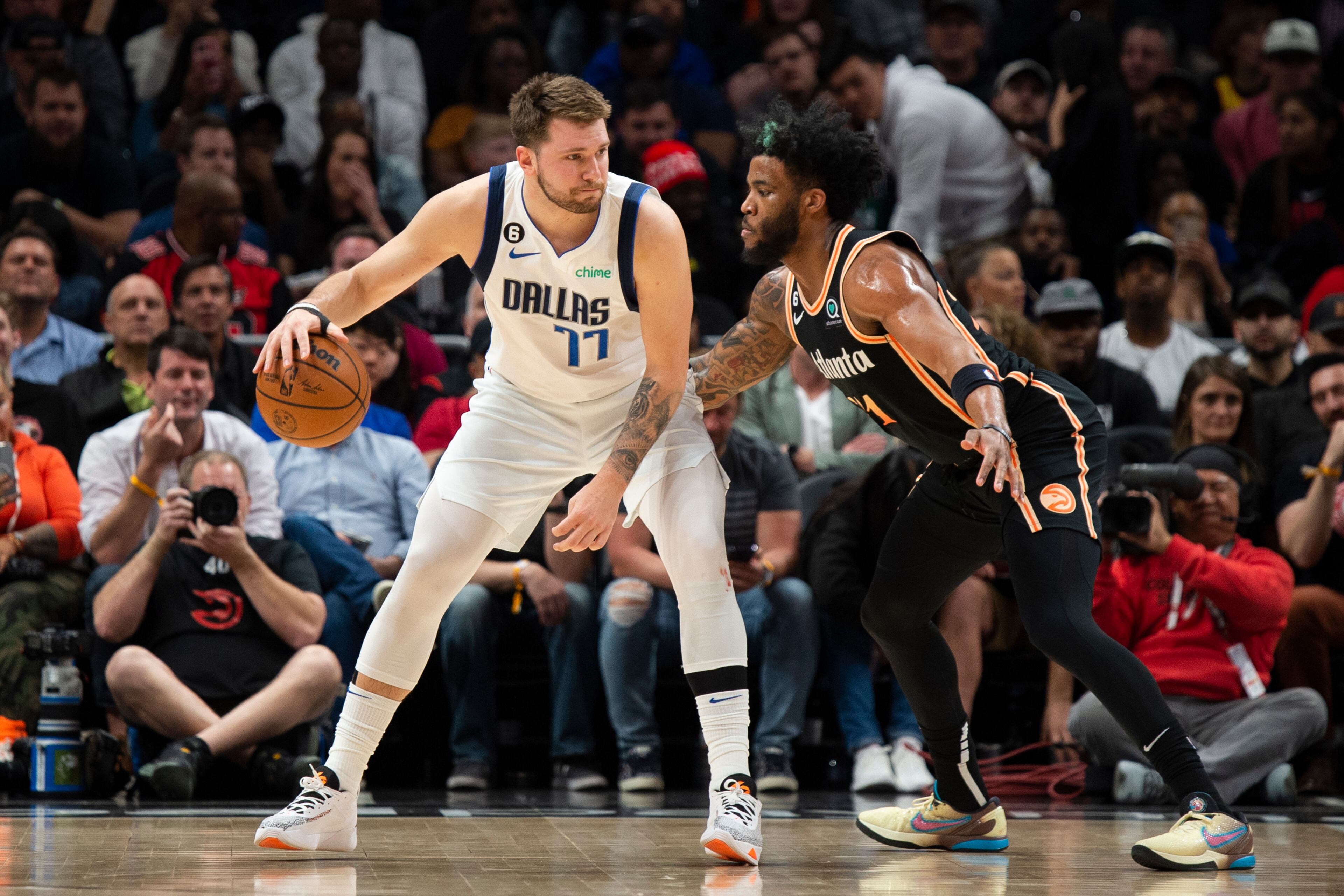Mavericks guard Luka Doncic (77) dribbles against Hawks forward Saddiq Bey during the first half of an NBA basketball game, Sunday, April 2, 2023, in Atlanta.