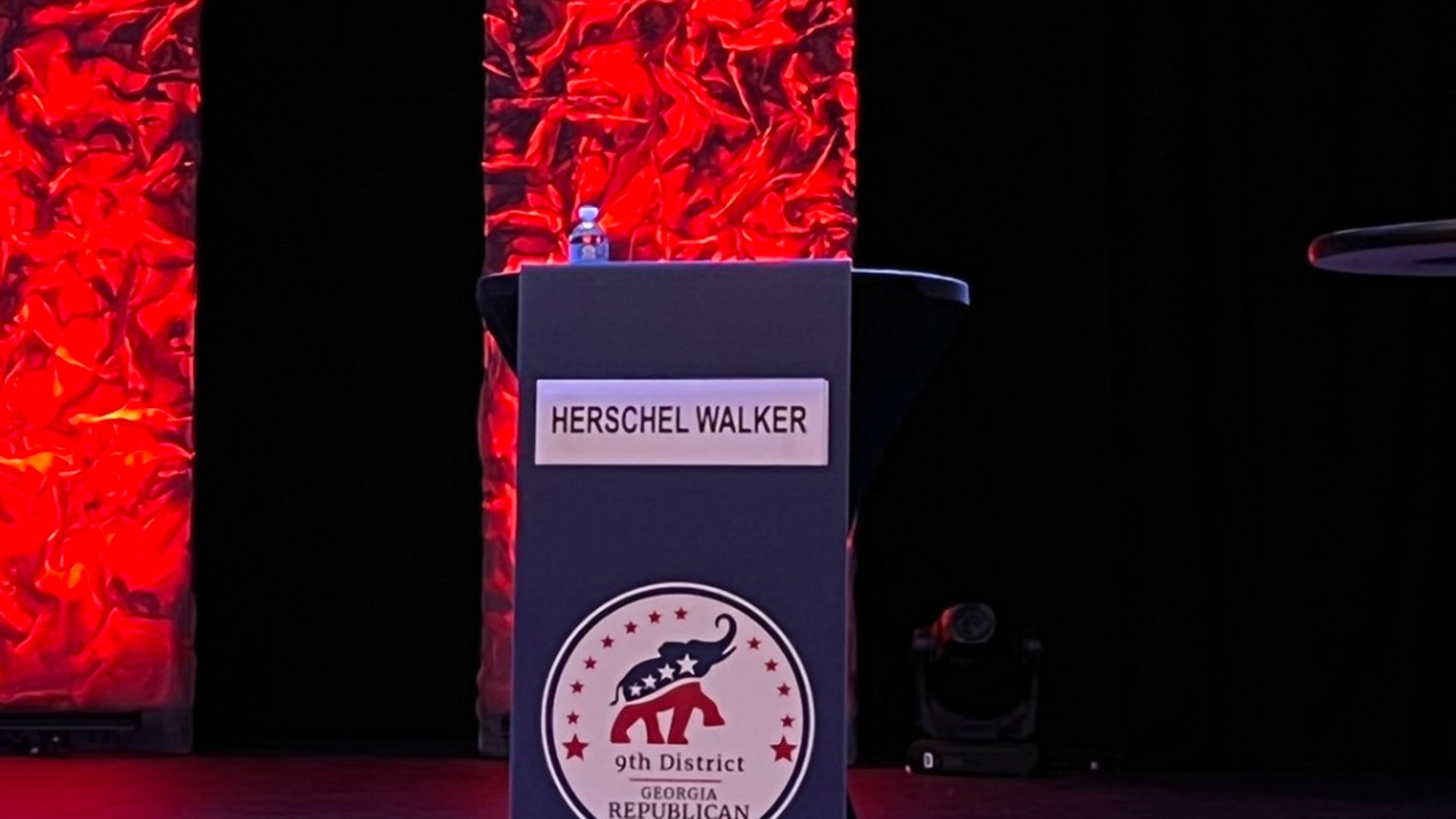 An image of Herschel Walker’s empty podium at the 9th District GOP debate in Gainesville.