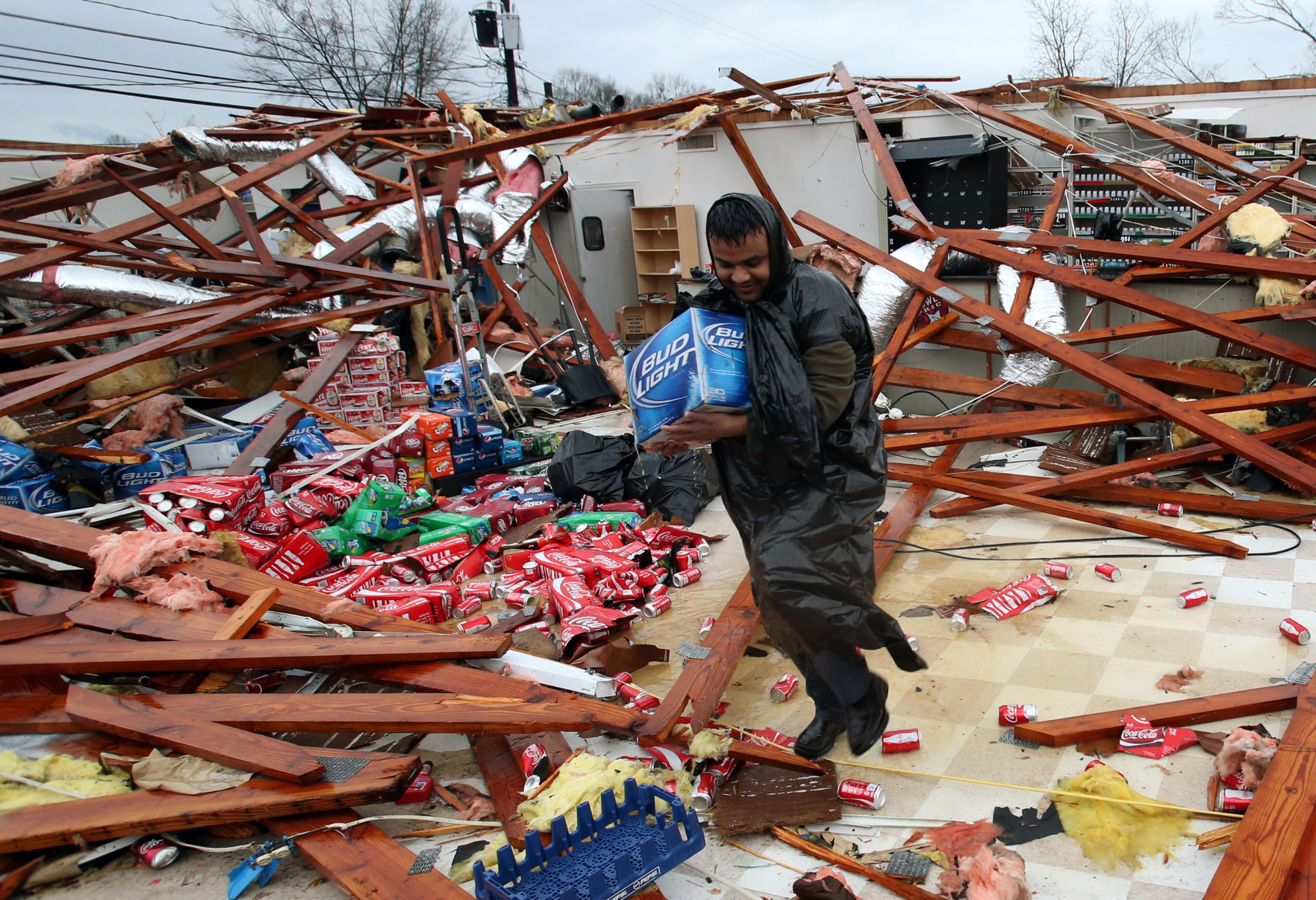 Pankaj Patel tries to salvage some of the products from his cousin's store, Adairsville Supermarket, following an afternoon tornado on Highway 41 Wednesday afternoon in Adairsville. The store is owned by Shyam Patel.