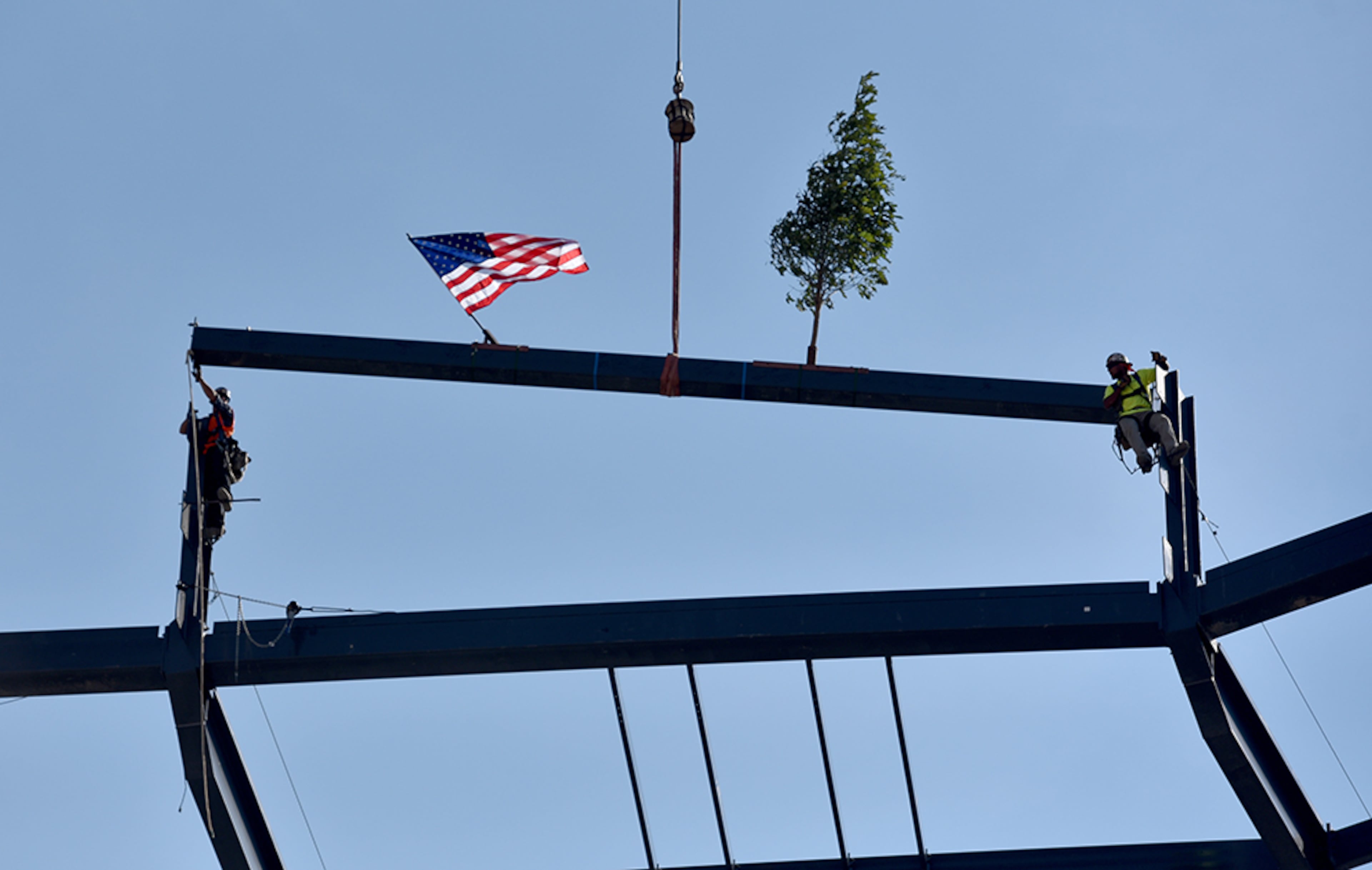 In keeping with construction industry tradition a ceremony is held to mark the installation of the highest or last piece of steel is put into place. Steel workers guide a beam into place atop the Braves' new Stadium in Cobb County Monday. An American Flag and an Ash tree fly on top on the beam installed during the "topping out" ceremony. Tradition calls for an evergreen tree to be placed atop the beam to appease the tree-dwelling spirits displaced during construction. The Braves decided to go with an Ash tree since that is the wood most major-league baseball bats are made from.