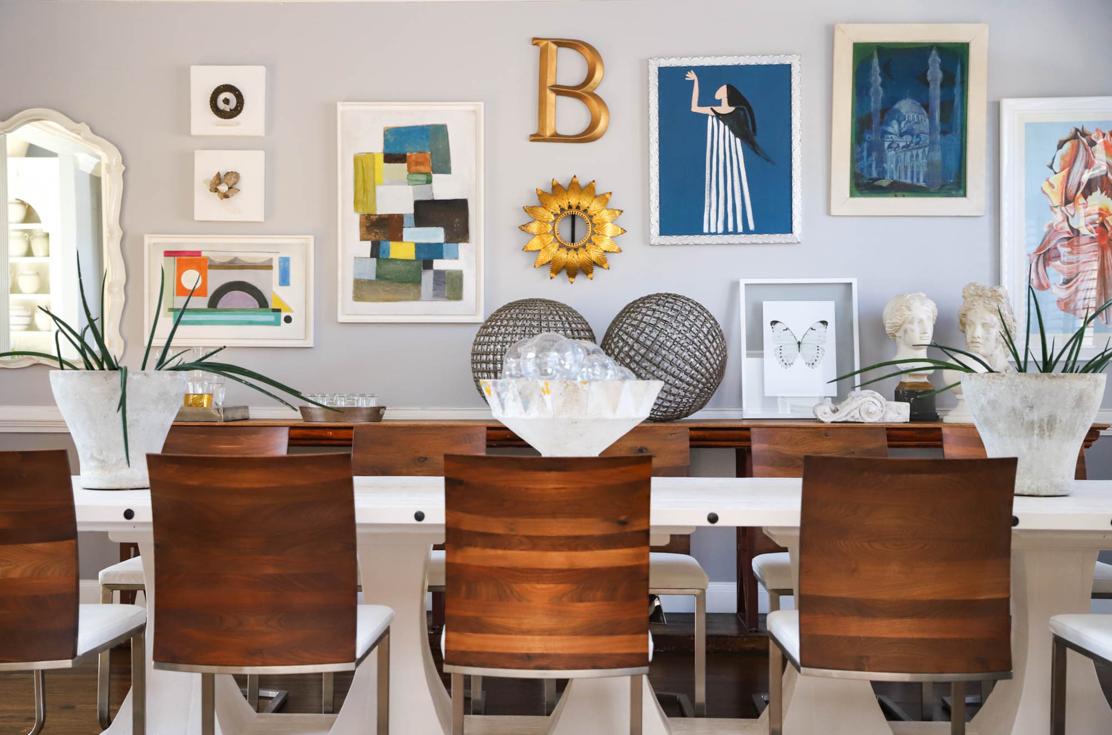 Pieces by local designer Lisa Burnett and a print by Lowell Blair Nesbit join art from France and a sunburst piece from a Spanish light to create a gallery wall in the dining room of Stacy and Joe Borocz’s Roswell home. The couple own etúHome, a home decor brand based in Atlanta, and in their search for pieces and inspiration for their brand, they often stumble upon pieces of art and furniture that they want in their own home. Text by Shannon Dominy/Photo by Reynolds Rogers