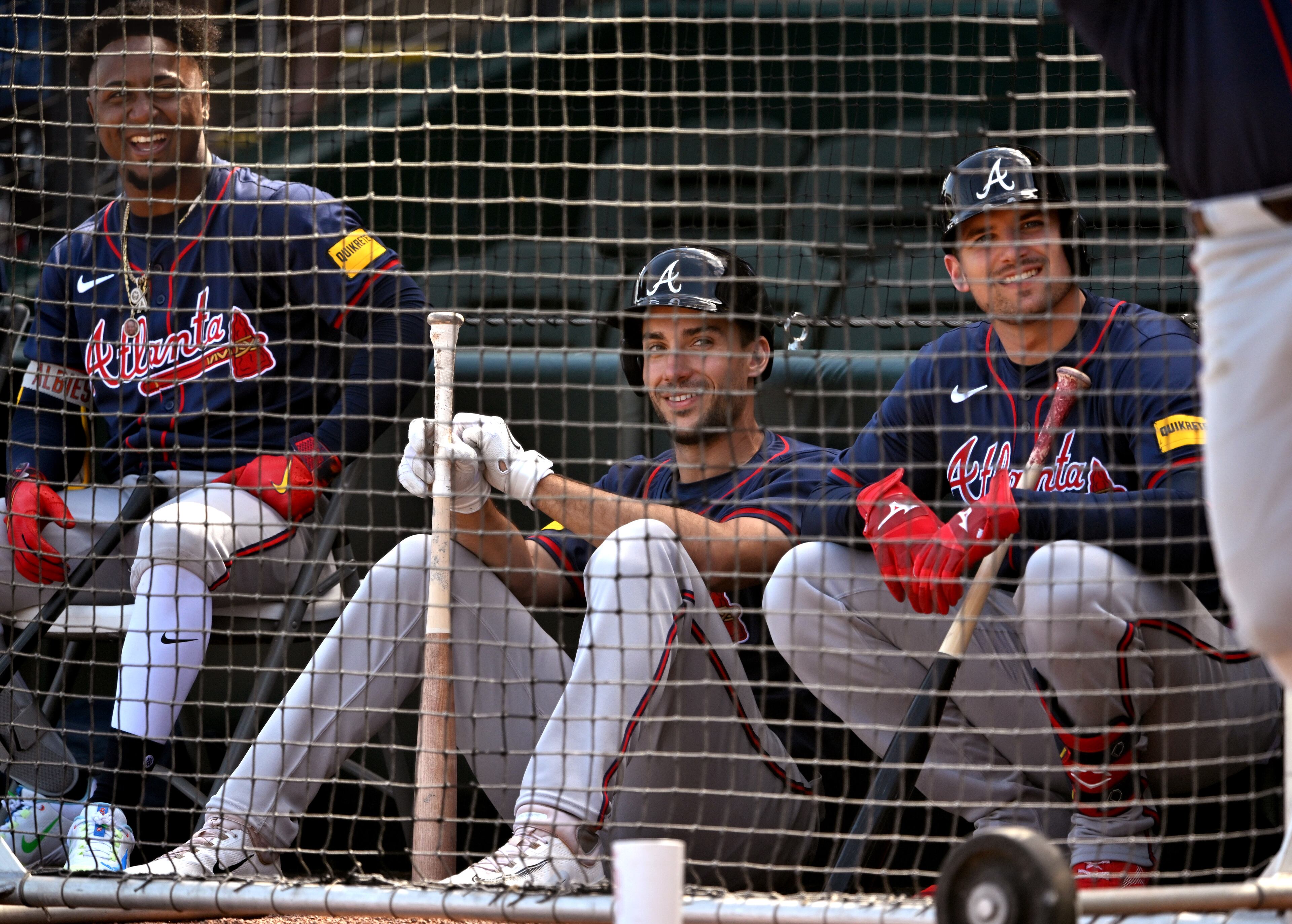 Atlanta Braves second baseman Ozzie Albies (from left), first baseman Matt Olson and third baseman Austin Riley react as they wait for their turn during spring training workouts at CoolToday Park, Friday, Feb. 23, 2024, in North Port, Florida. (Hyosub Shin / Hyosub.Shin@ajc.com)