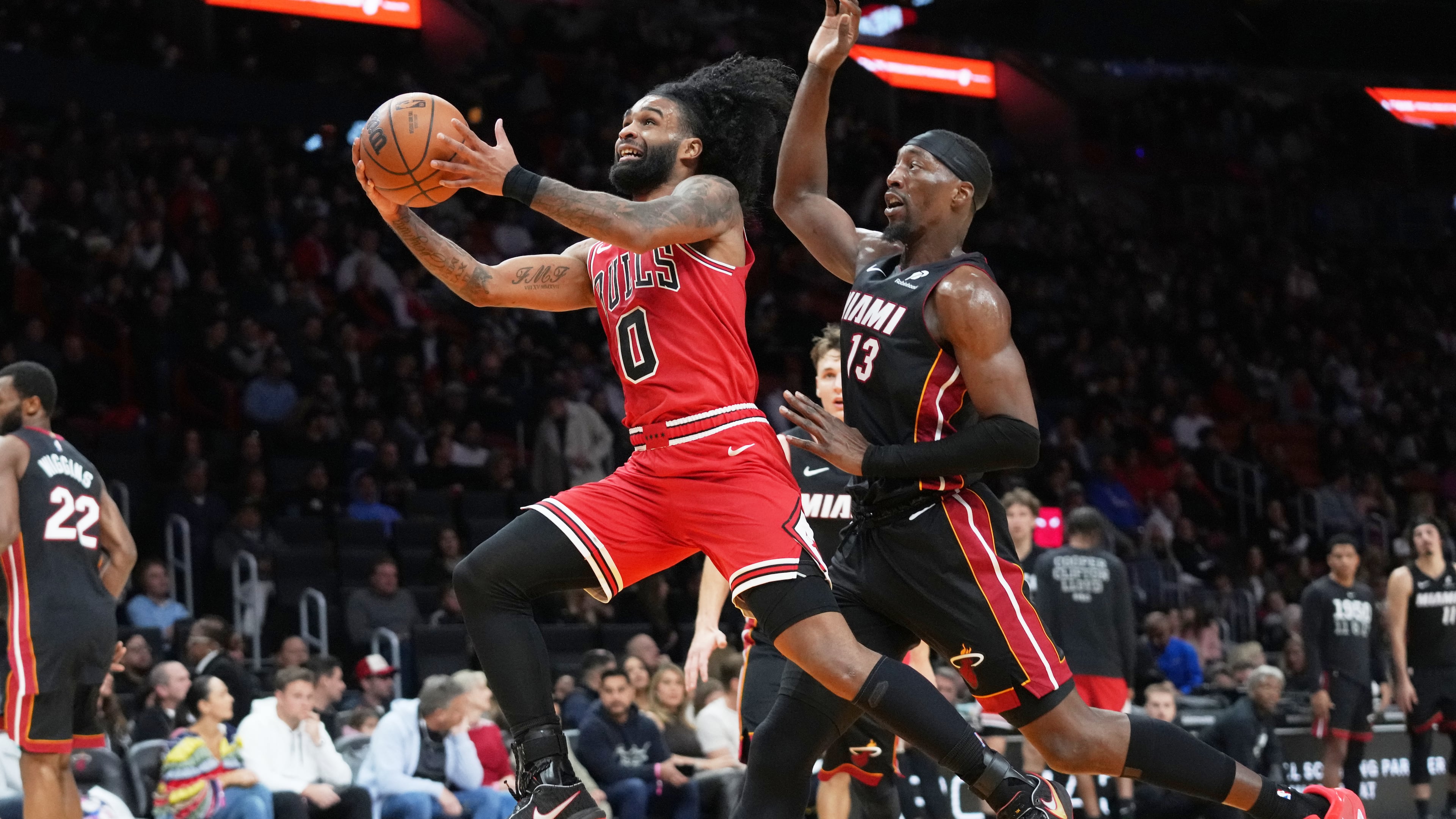 Chicago Bulls guard Coby White (0) drives to the basket as Miami Heat center Bam Adebayo (13) defends during the second half of an NBA basketball game, Sunday, Feb. 1, 2026, in Miami. (AP Photo/Lynne Sladky)