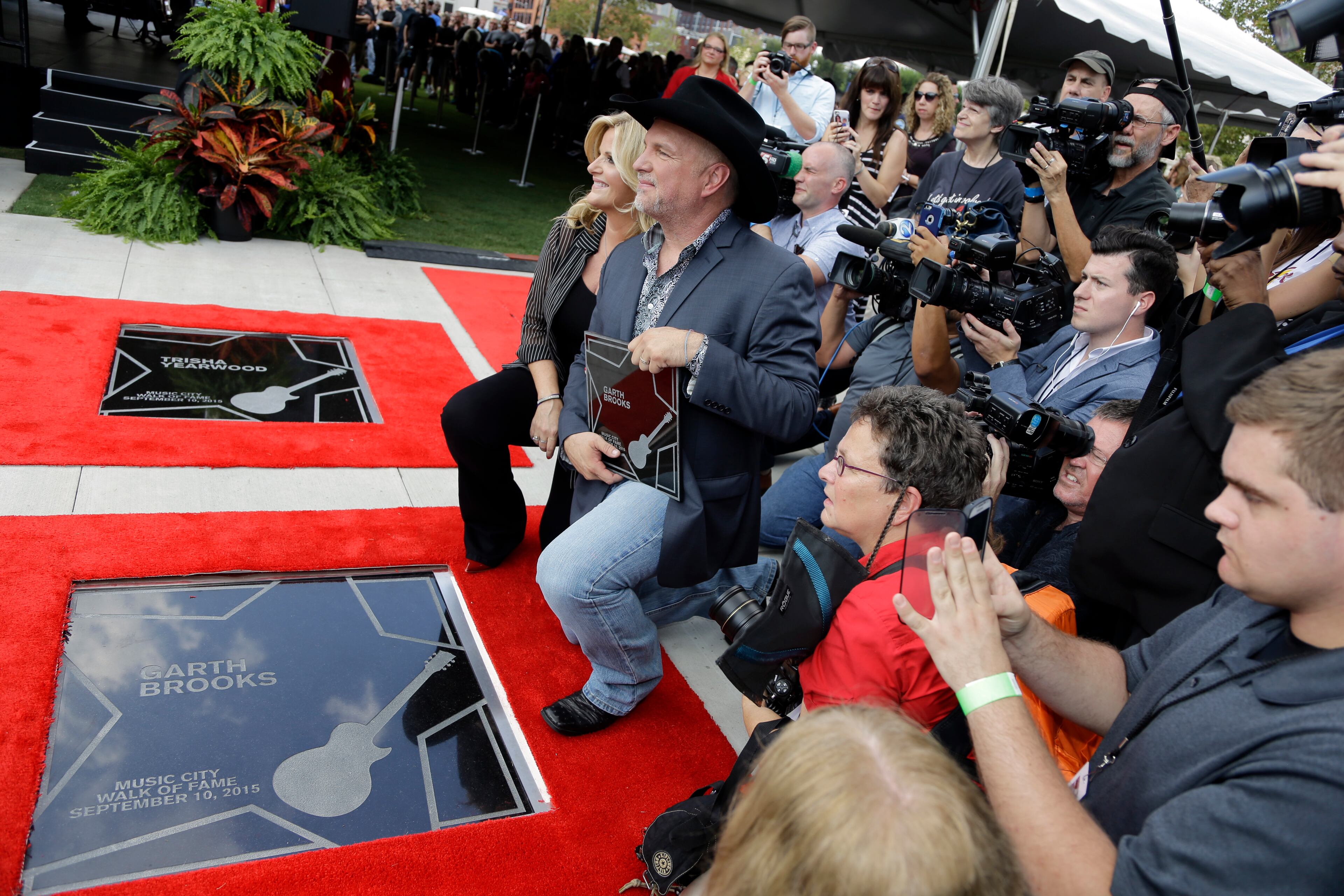 Garth Brooks and Trisha Yearwood pose by Brooks' star on the Music City Walk of Fame on Thursday, Sept. 10, 2015, in Nashville, Tenn. (AP Photo/Mark Humphrey)