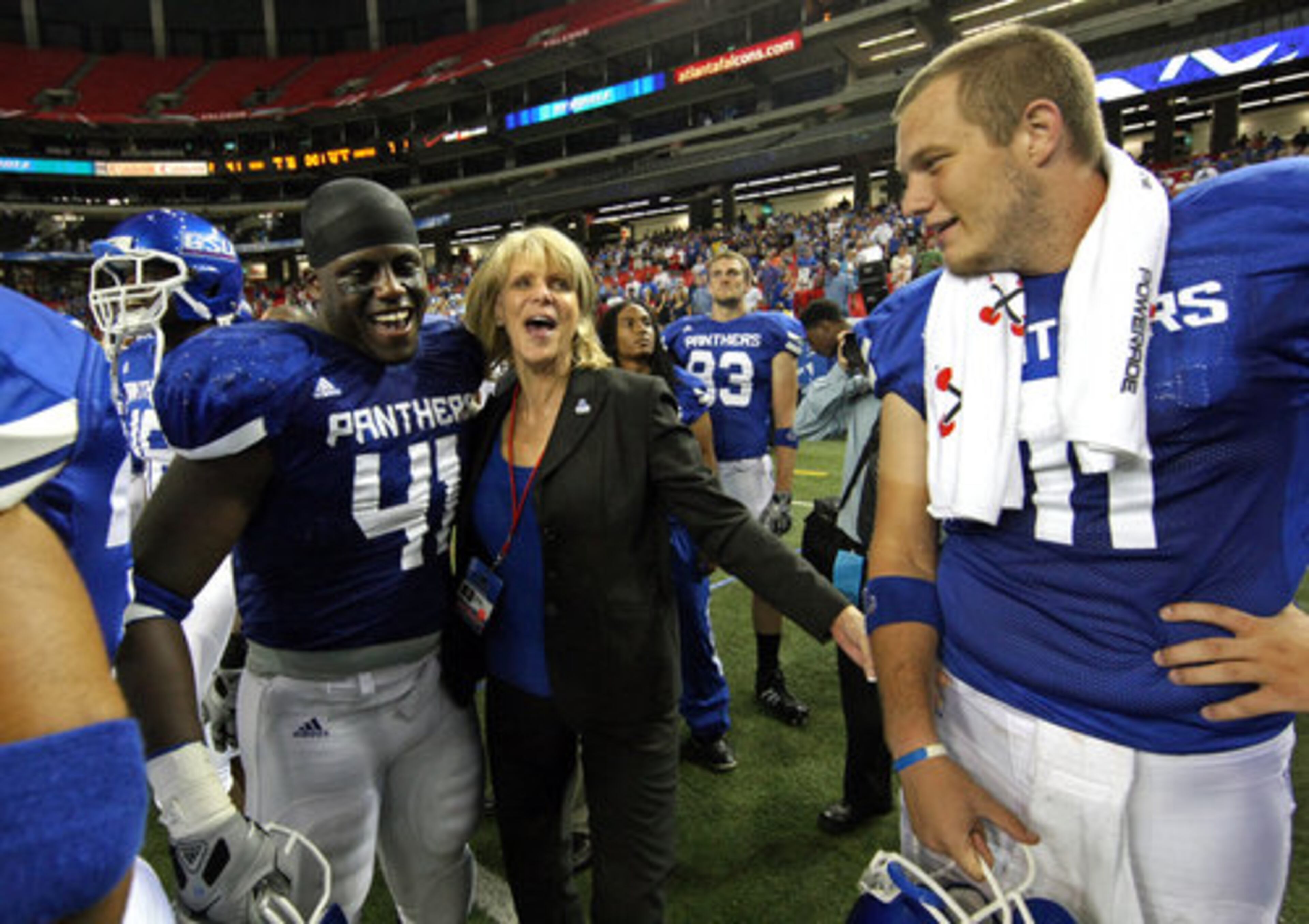 GSU Athletic Director Cheryl Levick, center, celebrates with linebacker Olufemi Opanubi (41) and quarterback Drew Little (11) in the closing minutes of their 41-7 win over Shorter College for their first ever win in the Georgia Dome Thursday night in Atlanta, Ga., Sept. 2, 2010.