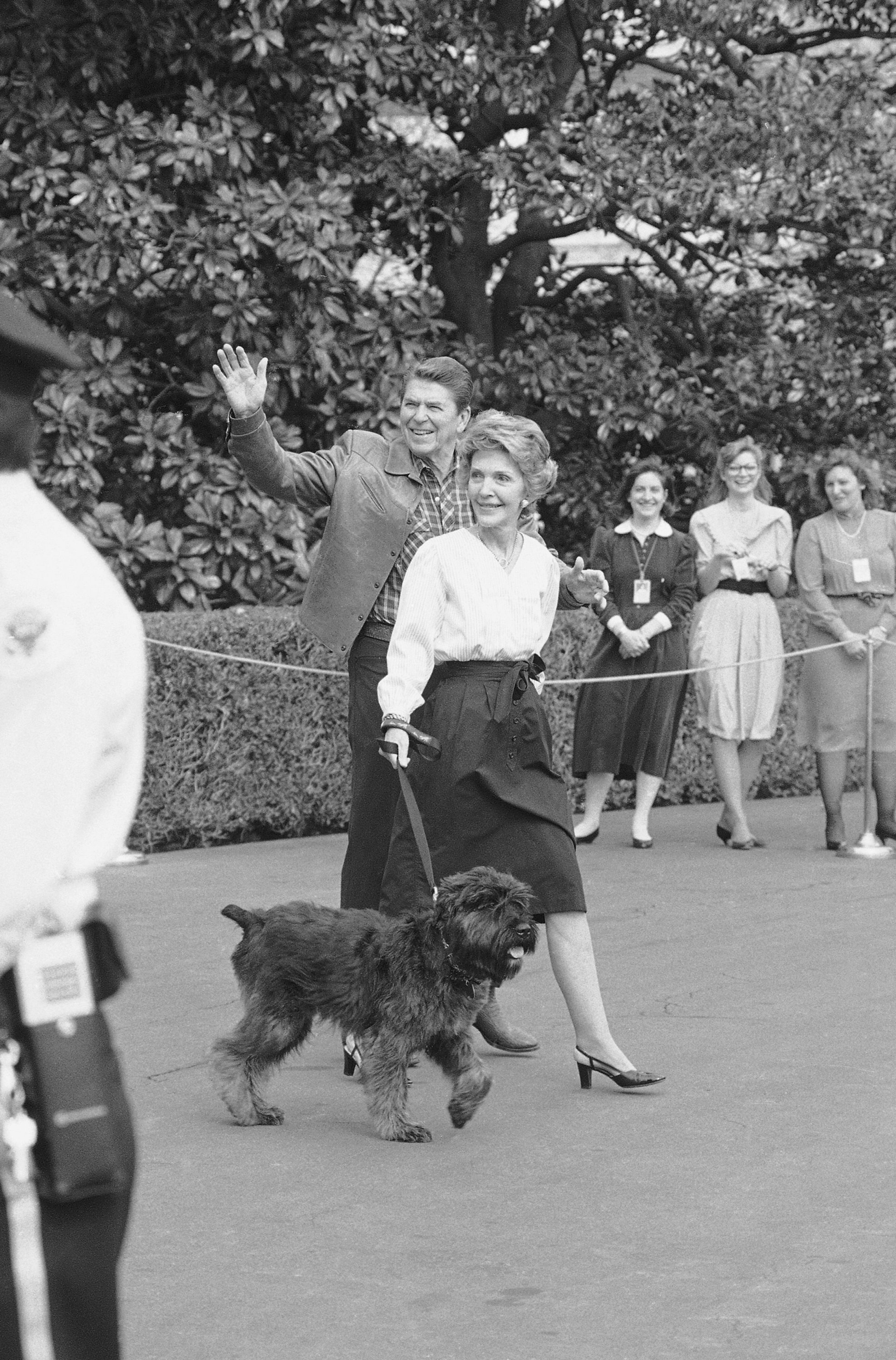 In this Jan. 6, 1985 black-and-white file photo, President Reagan and first lady Nancy Reagan walk toward the White House in Washington, with their dog "Lucky," shortly after returning from a weekend at the presidential retreat at Camp David, Md. (AP Photo/Ron Edmonds, File)