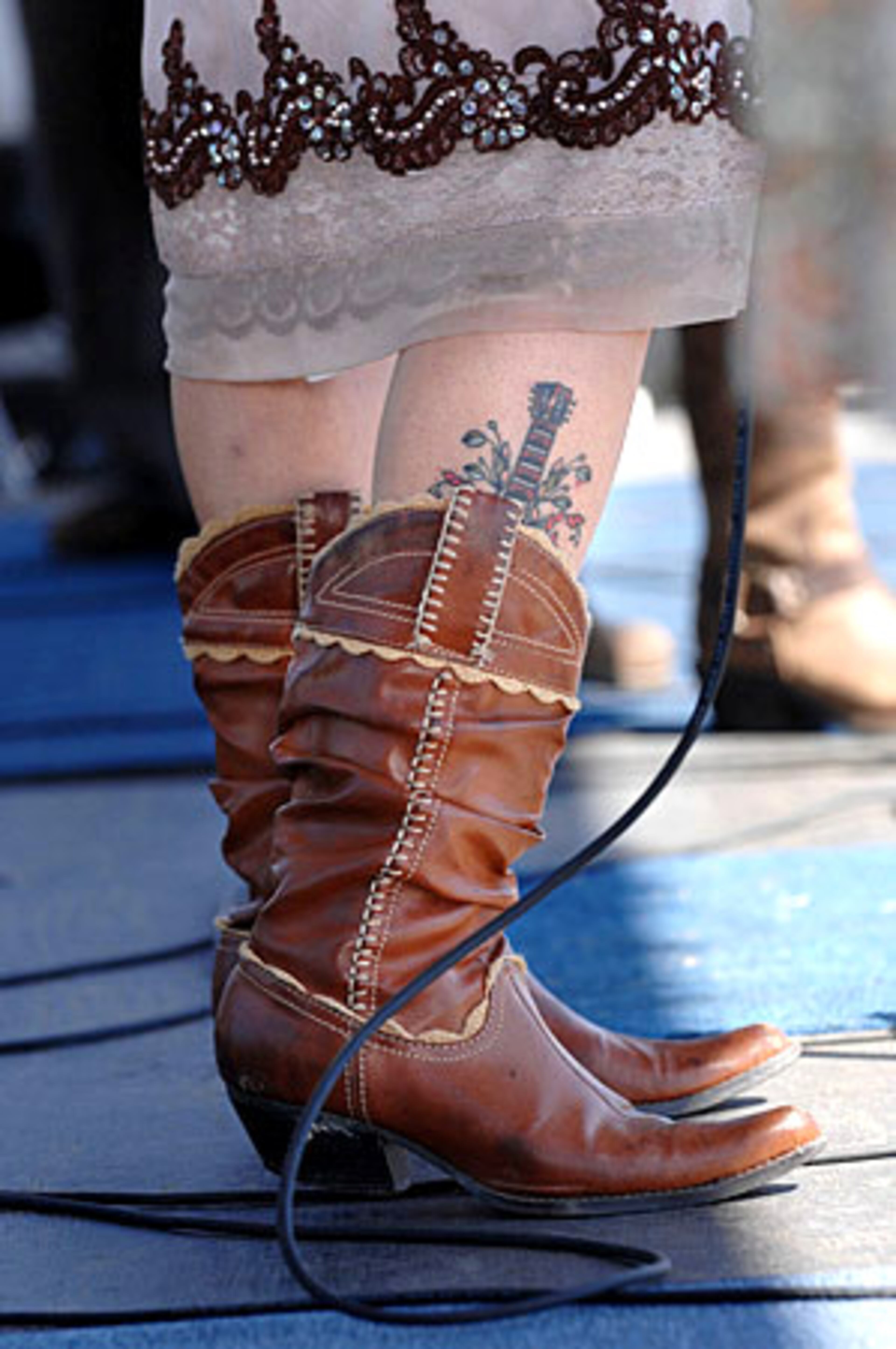 Jane Edens, with the all-female acoustic country folk band Barrel House Mamas, shows her tattoo of a resonator guitar.