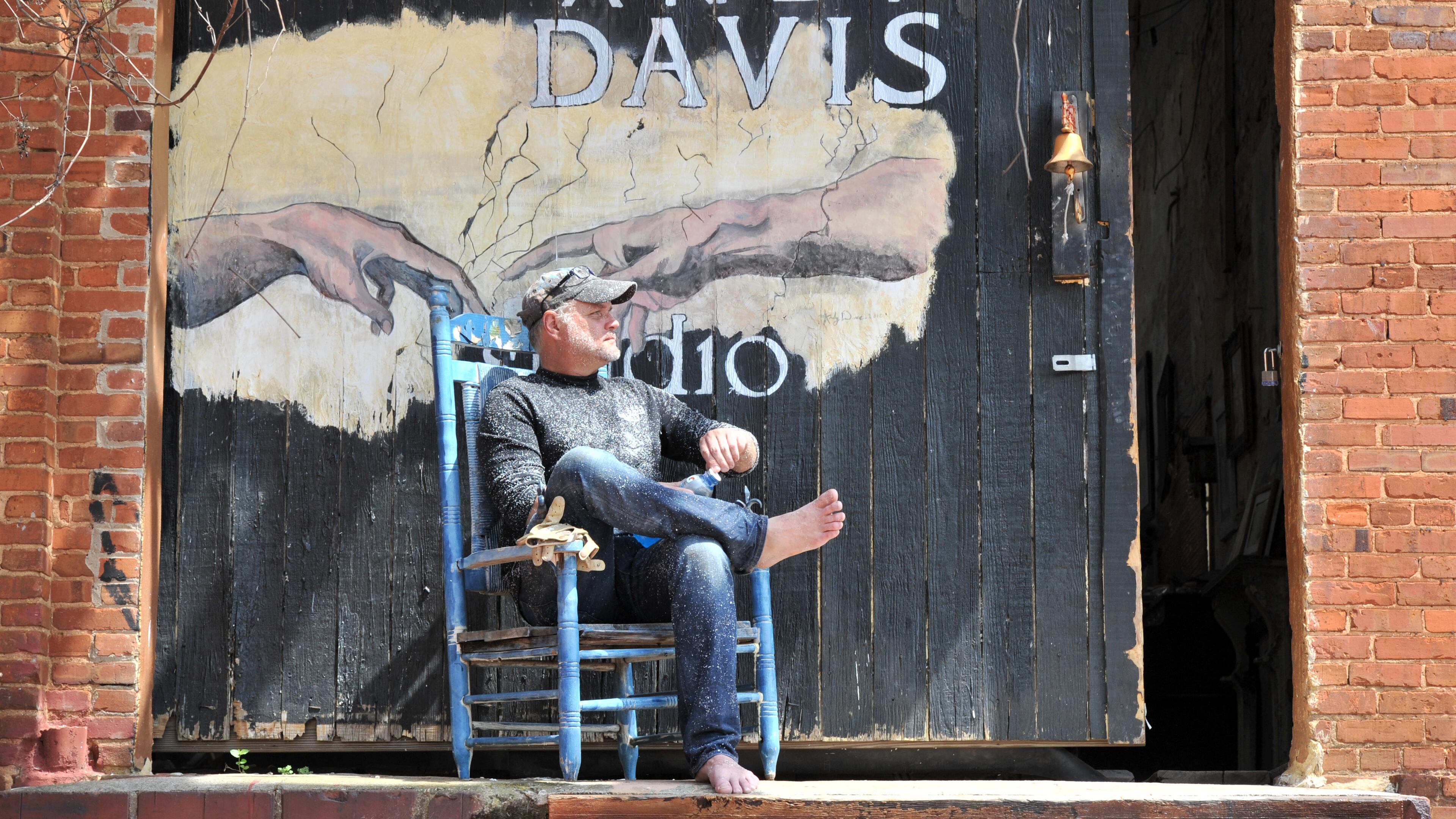 Andy Davis takes a short break as he helps his assistant Rachel Williams working on her first commissioned work. HYOSUB SHIN / HSHIN@AJC.COM