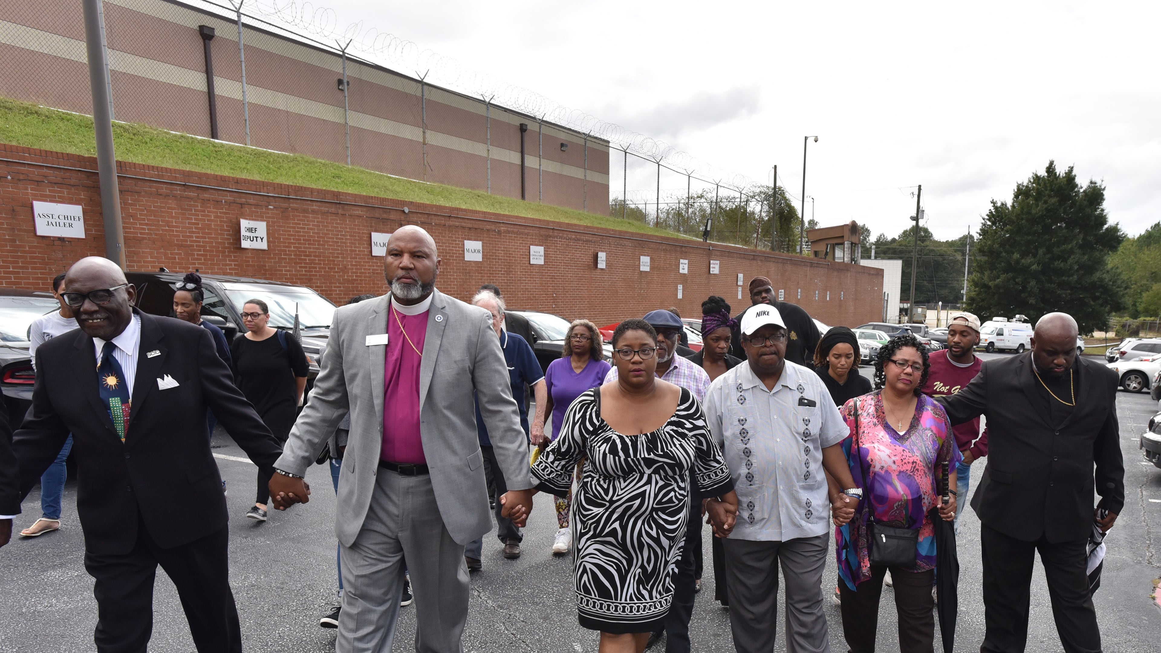 Tamara Cotman, center, holds hands with supporters as she walks to the Fulton County Jail Tuesday. Cotman, convicted in the Atlanta Public Schools cheating scandal, will begin serving her prison sentence after her appeals ran out.