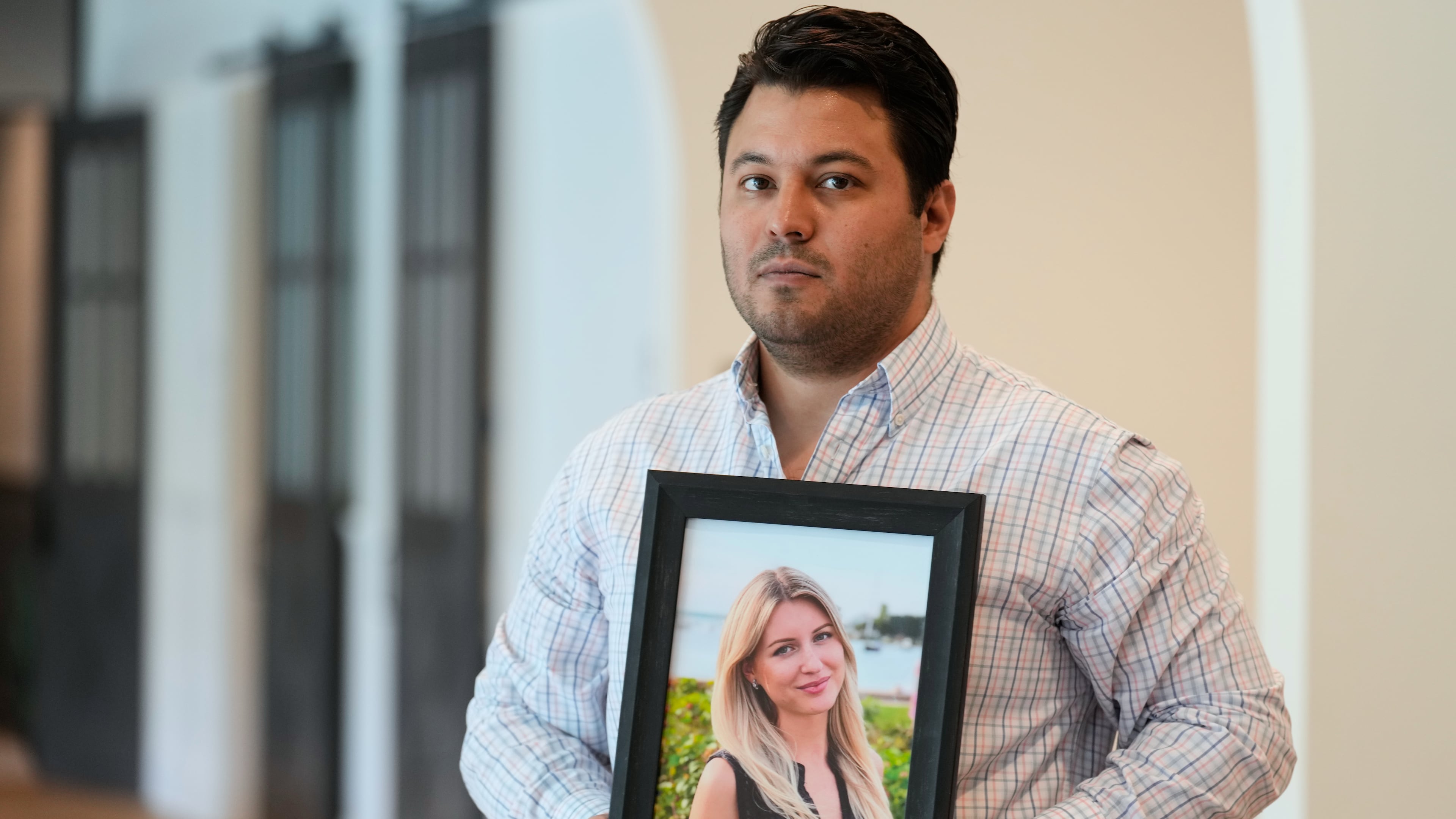 Harold Jezler poses for a picture with a photo of his wife, Olga Jezler, in West Harrison, N.Y., Friday, Aug. 21, 2026. (AP Photo/Seth Wenig)