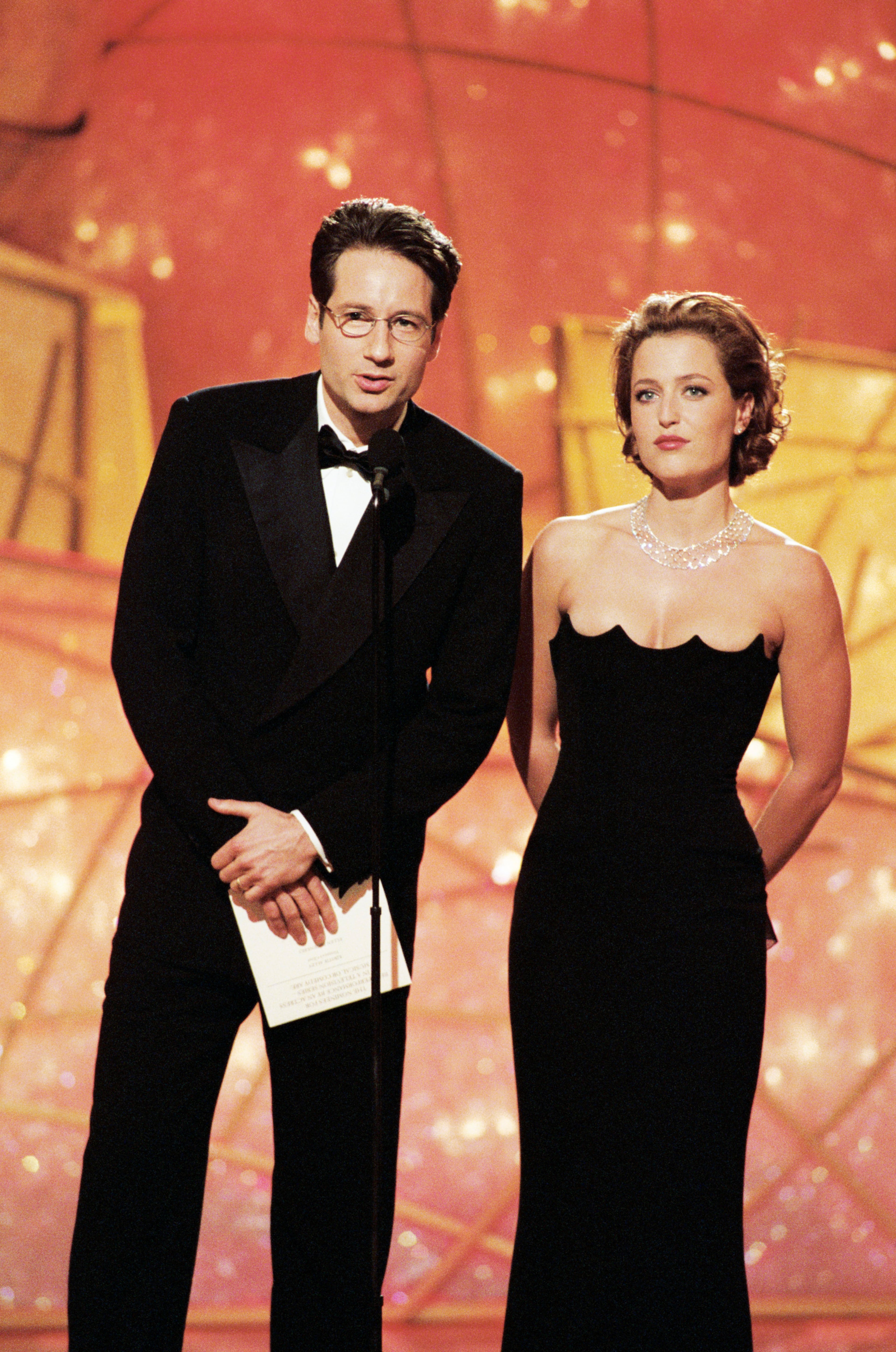 55TH ANNUAL GOLDEN GLOBE AWARDS -- Pictured: (l-r) Golden Globe presenters and winners for best Television Series - Drama "X-Files" David Duchovny, Gillian Anderson on stage during the 55th Annual Golden Globe Awards held at the Beverly Hilton Hotel on January 18, 1998 (Photo by Fitzroy Barrett/NBC/NBCU Photo Bank via Getty Images)