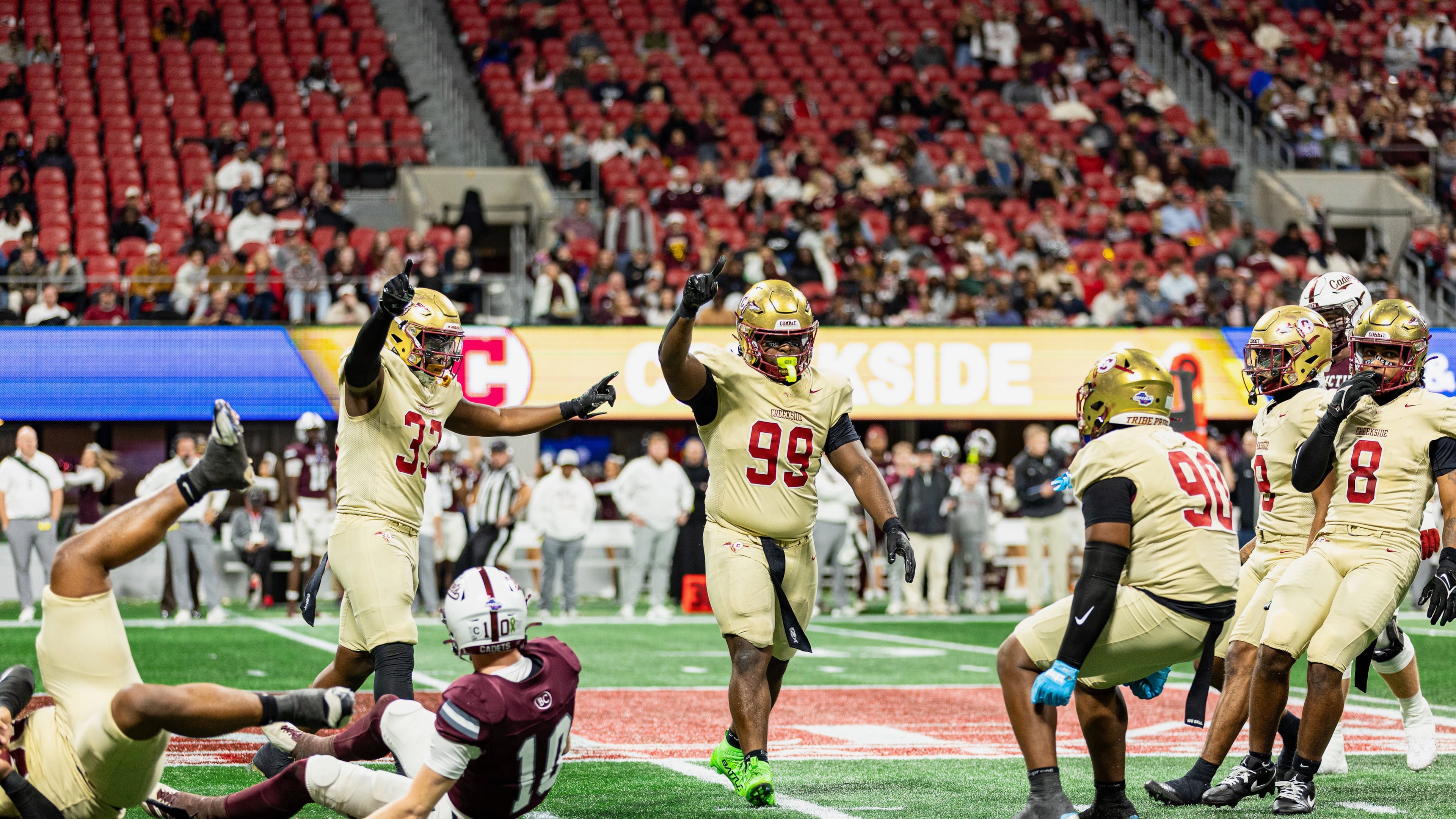 Creekside's Daniel Holt (right center, with blue gloves) celebrates with teammates Tavarre Terrell (left center, with two arms raised) and Cassius Burch (center, with one arm raised) during the GHSA Class 4A state championship game vs. Benedictine in December. The Seminoles won 42-39. (Courtesy of Cassius Burch and IQue Media Group)
