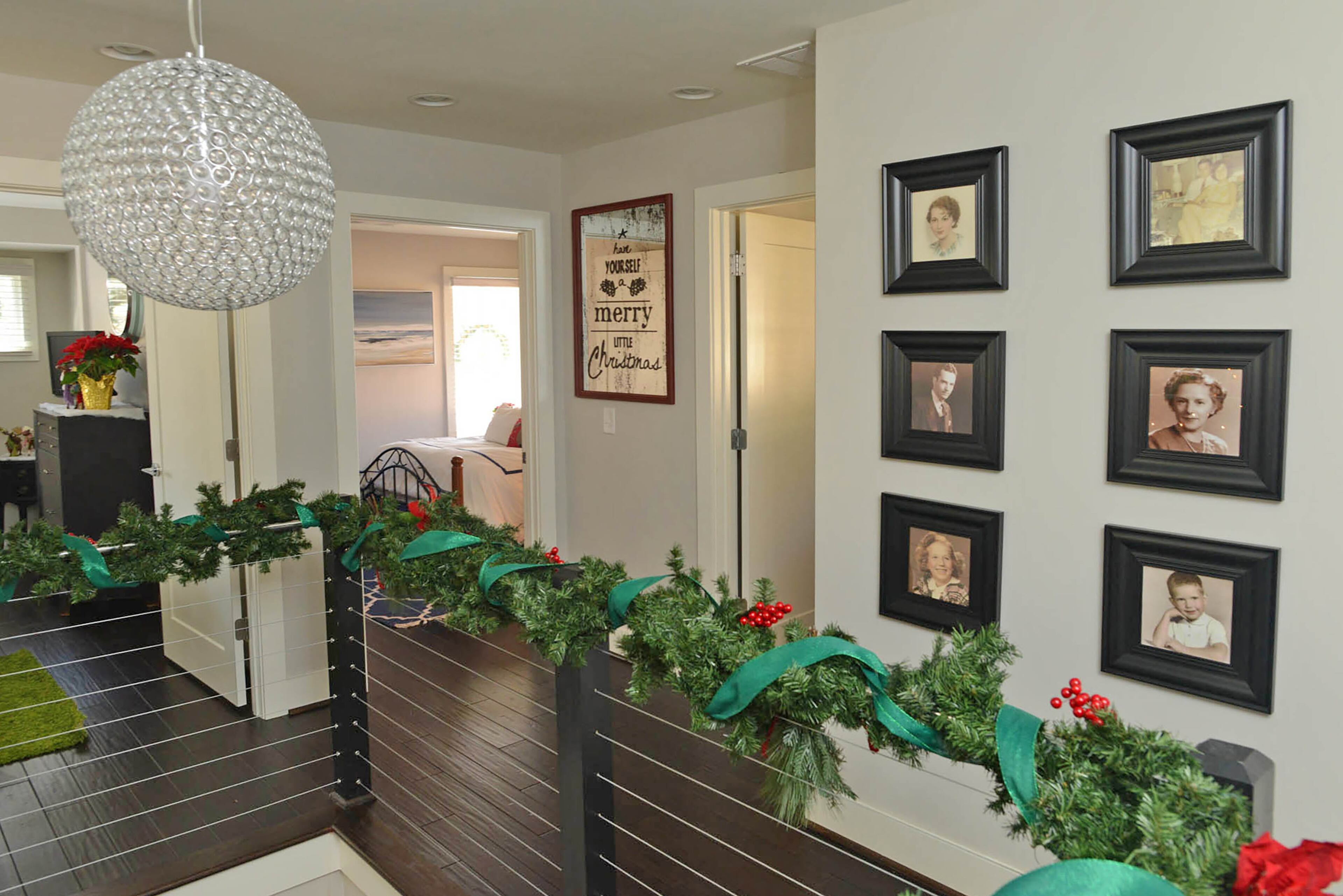 The modern stair rail, made of cables, gets a holiday update with garland and berries for the tour.