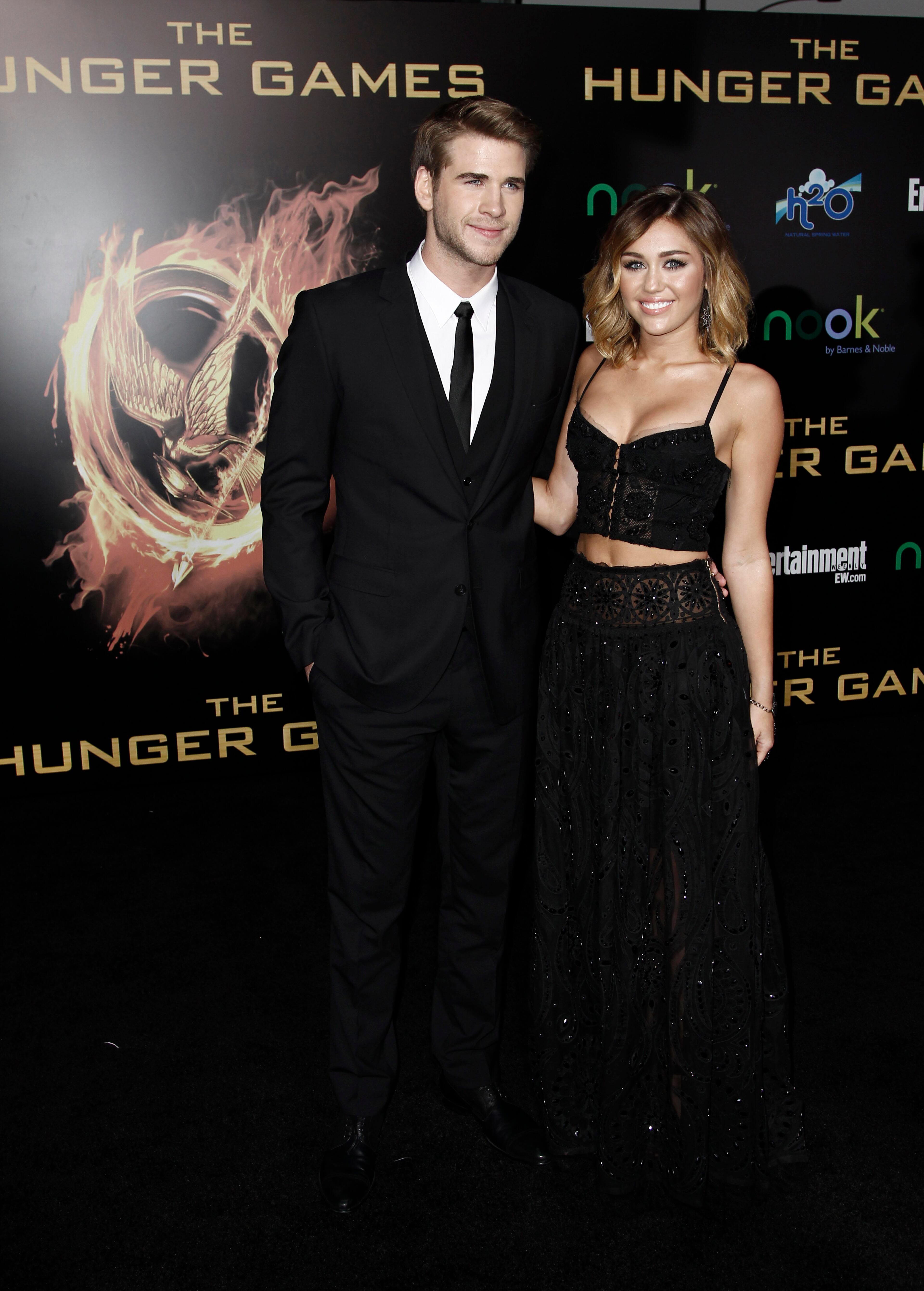 Liam Hemsworth, left, and Miley Cyrus arrive at the world premiere of "The Hunger Games" on Monday March 12, 2012 in Los Angeles. (AP Photo/Matt Sayles)
