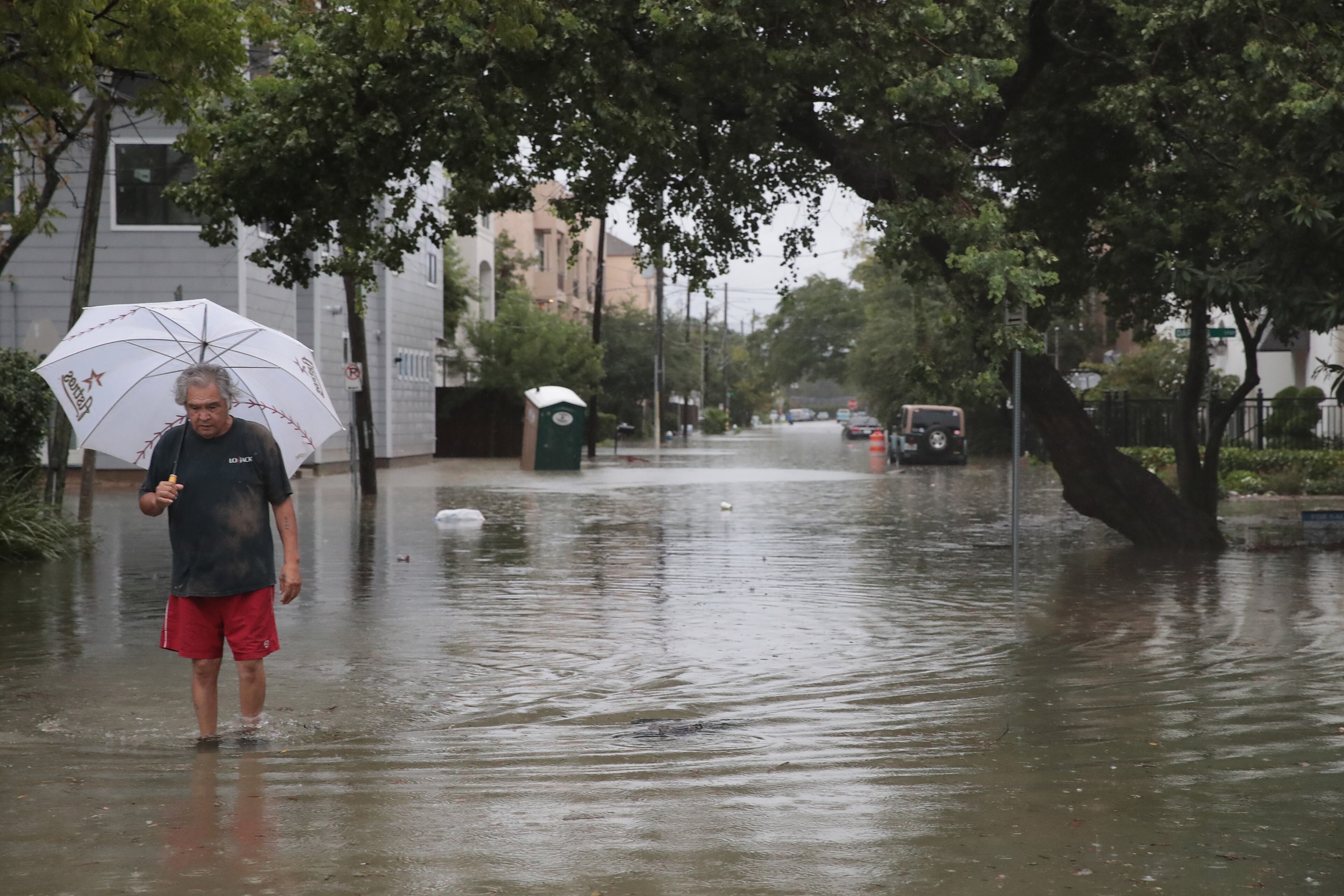HOUSTON, TX - AUGUST 27: Lee Padilla walks down the street in the Cottage Grove neighborhood which has been inundated with floodingf from Hurricane Harvey on August 27, 2017 in Houston, Texas. Harvey, which made landfall north of Corpus Christi late Friday evening, is expected to dump upwards to 40 inches of rain in Texas over the next couple of days. (Photo by Scott Olson/Getty Images)