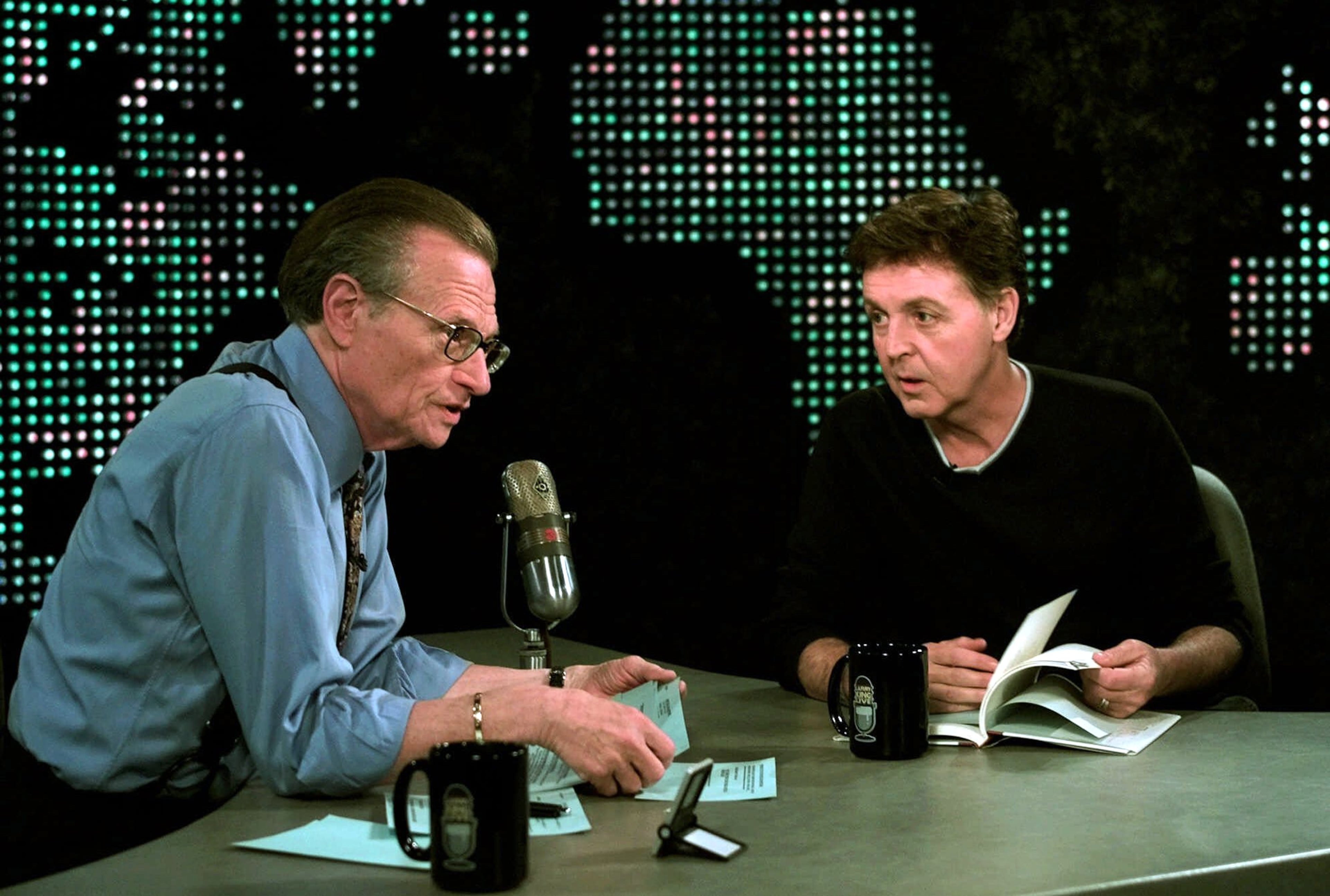 Music legend Paul McCartney, right, reads a poem from his new book: 'Blackbird Singing, Poems and Lyrics 1965-1999,' during an exclusive interview Tuesday, June 12, 2001, with Larry King at the CNN studios in Los Angeles. (AP Photo/Damian Dovarganes)