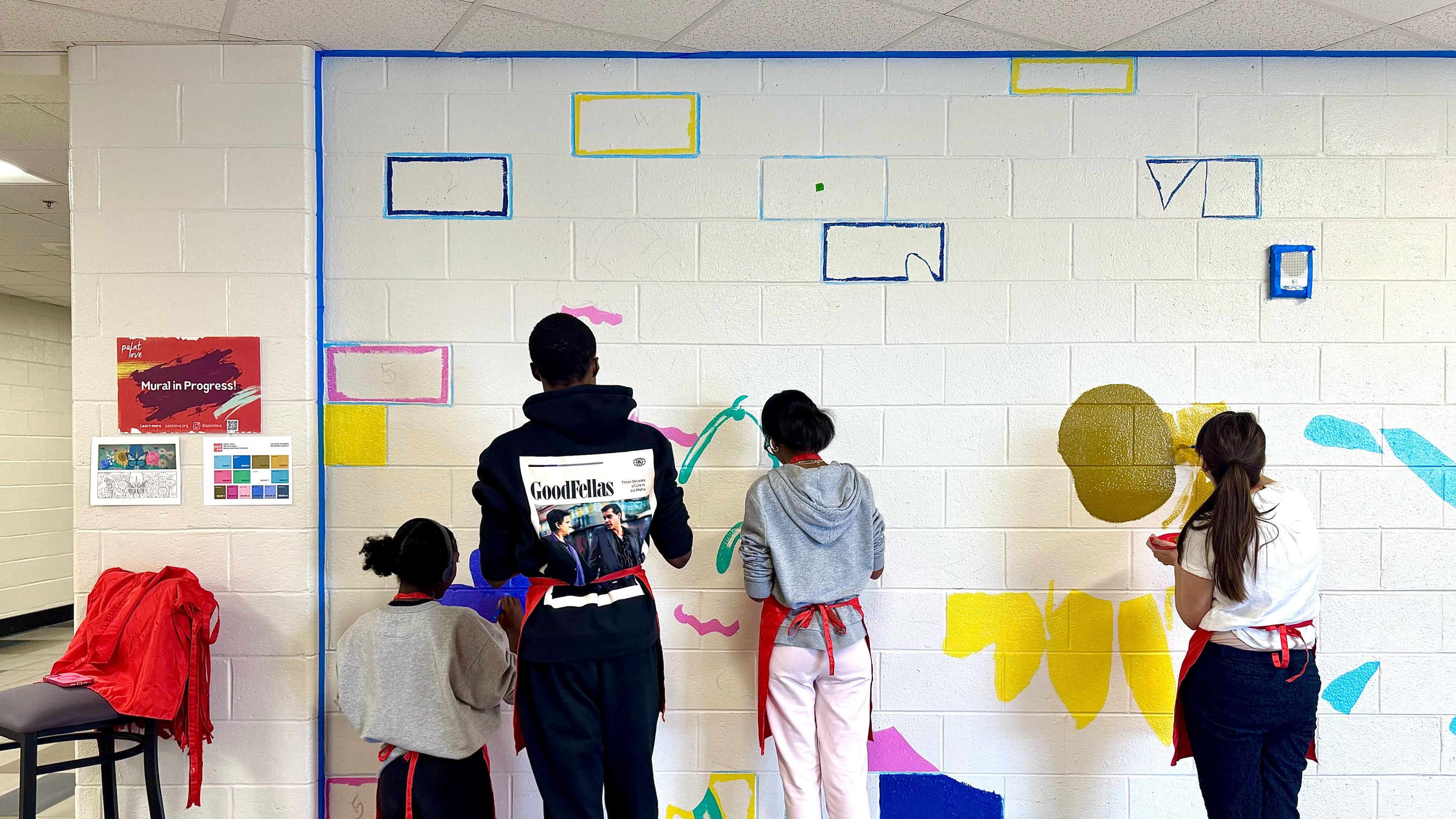 Students start to paint patches of color into the outline of a new mural at Apalachee High School on Monday, Aug. 25, 2025. The mural, created in partnership with nonprofit Paint Love, will brighten a hallway in time for the one-year anniversary of the shooting that killed two students and two teachers. (Courtesy of Paint Love)