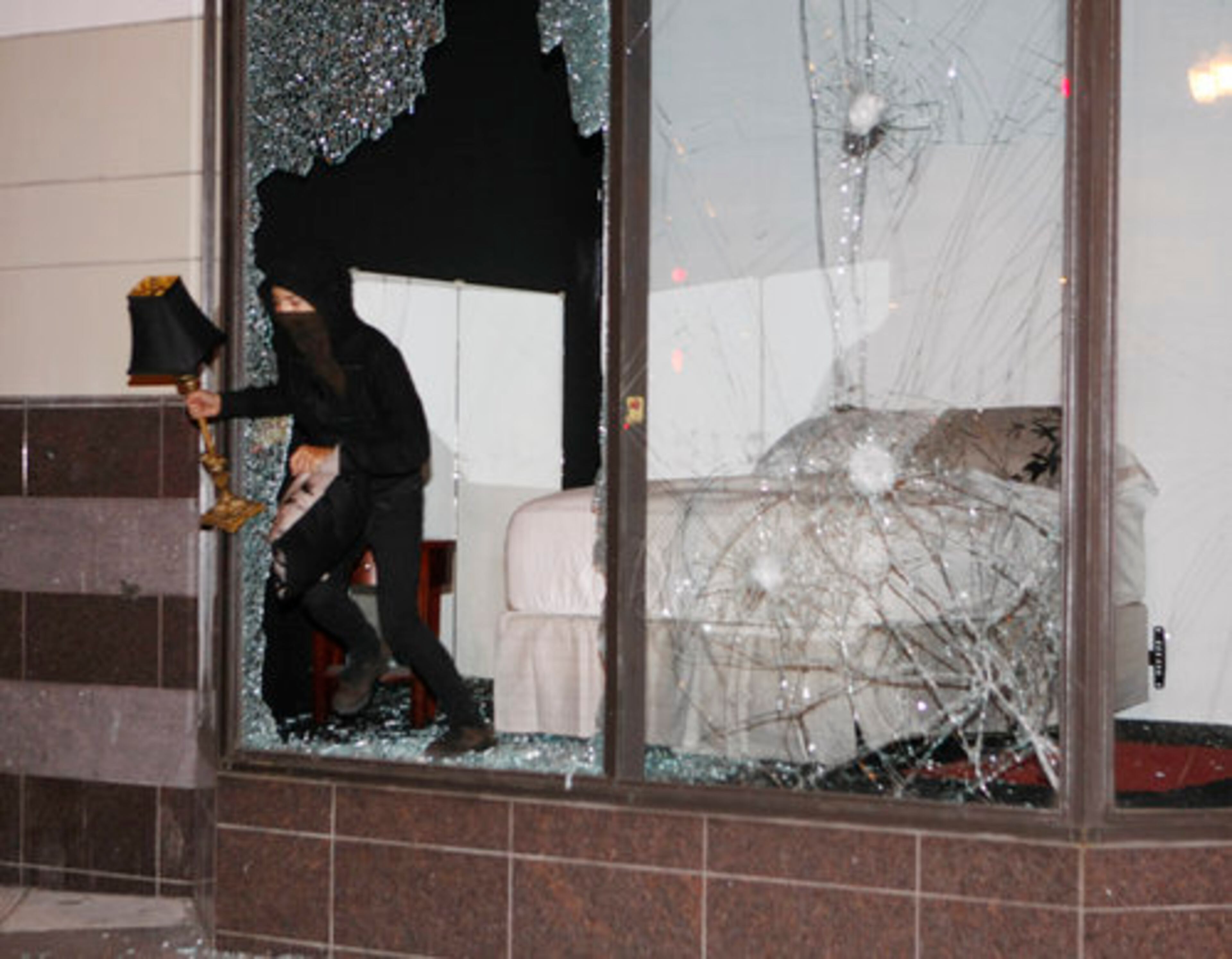 An unidentified person loots a Foot Locker store in Oakland, Calif., following an involuntary manslaughter verdict in Johannes Mehserle's trial on Thursday, July 8, 2010. A white former San Francisco Bay Area Rapid Transit police officer, Mehserle was found guilty of involuntary manslaughter in Los Angeles for shooting unarmed black man Oscar Grant on New Year's Day 2009 at a BART station in Oakland.