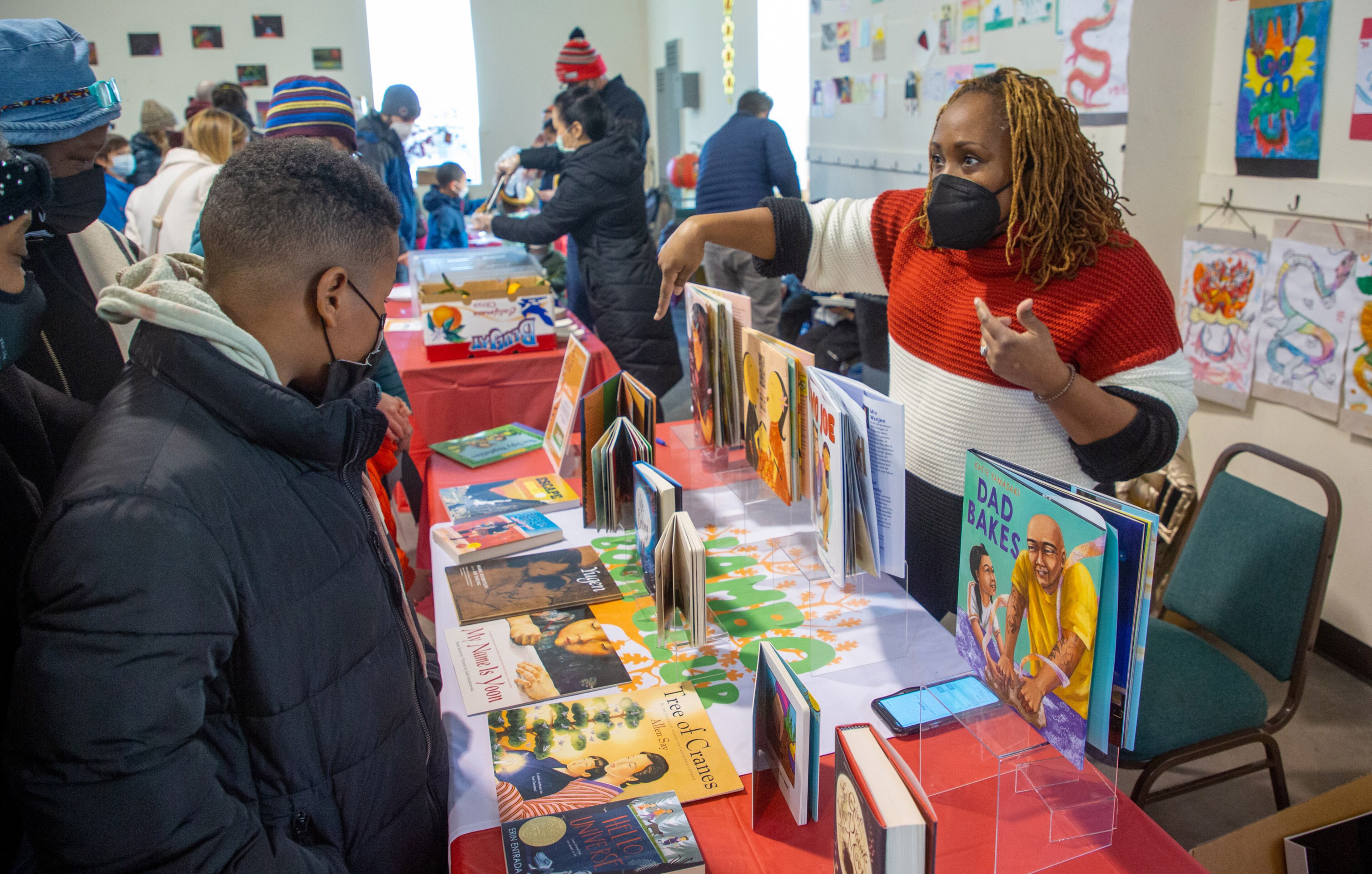 Book curator of Jambo Book Club, Mijha Godfrey, talks to customers during Decatur's first Lunar New Year celebration at Legacy Park on Saturday, January 29, 2022. STEVE SCHAEFER FOR THE ATLANTA JOURNAL-CONSTITUTION