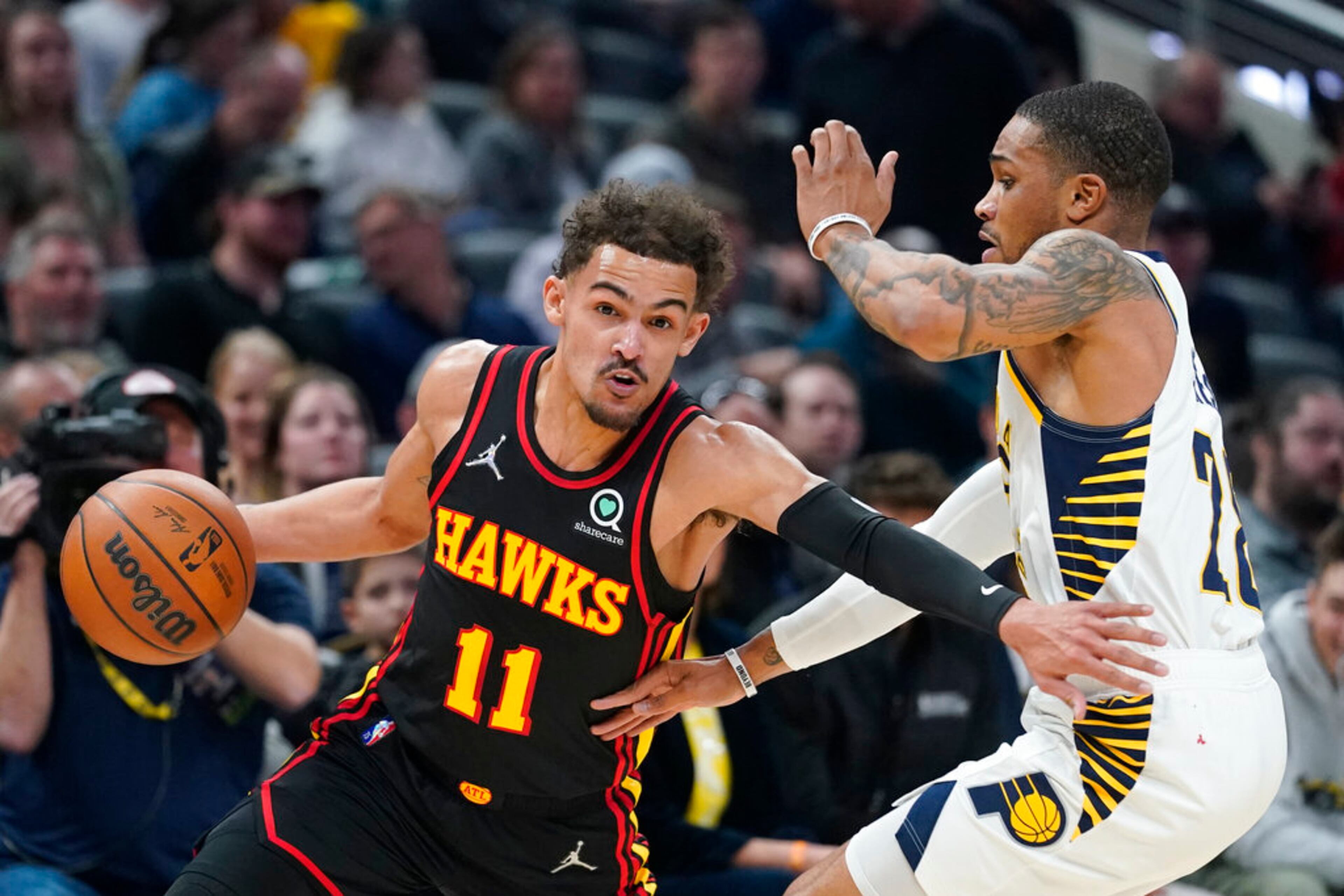 Atlanta Hawks' Trae Young (11) drives past Indiana Pacers' Keifer Sykes (28) during the first half of an NBA basketball game, Monday, March 28, 2022, in Indianapolis. (AP Photo/Darron Cummings)