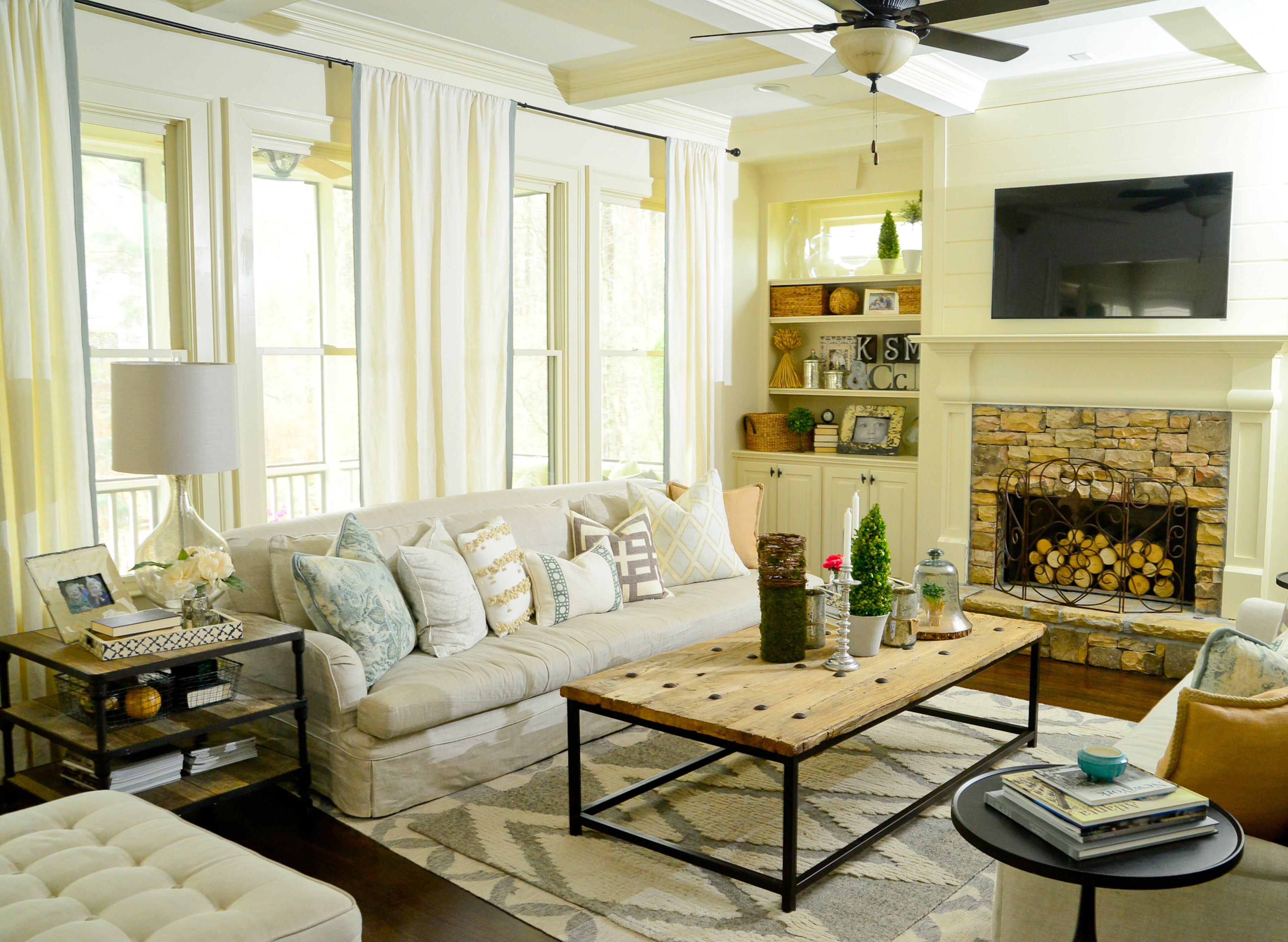 The living room is a mix of clever furniture, such as the barn door coffee table from Outrageous Interiors, and clearance buys, such as the end tables, linen sofas and the ottoman, from RH and Crate and Barrel. Text by Lori Johnston