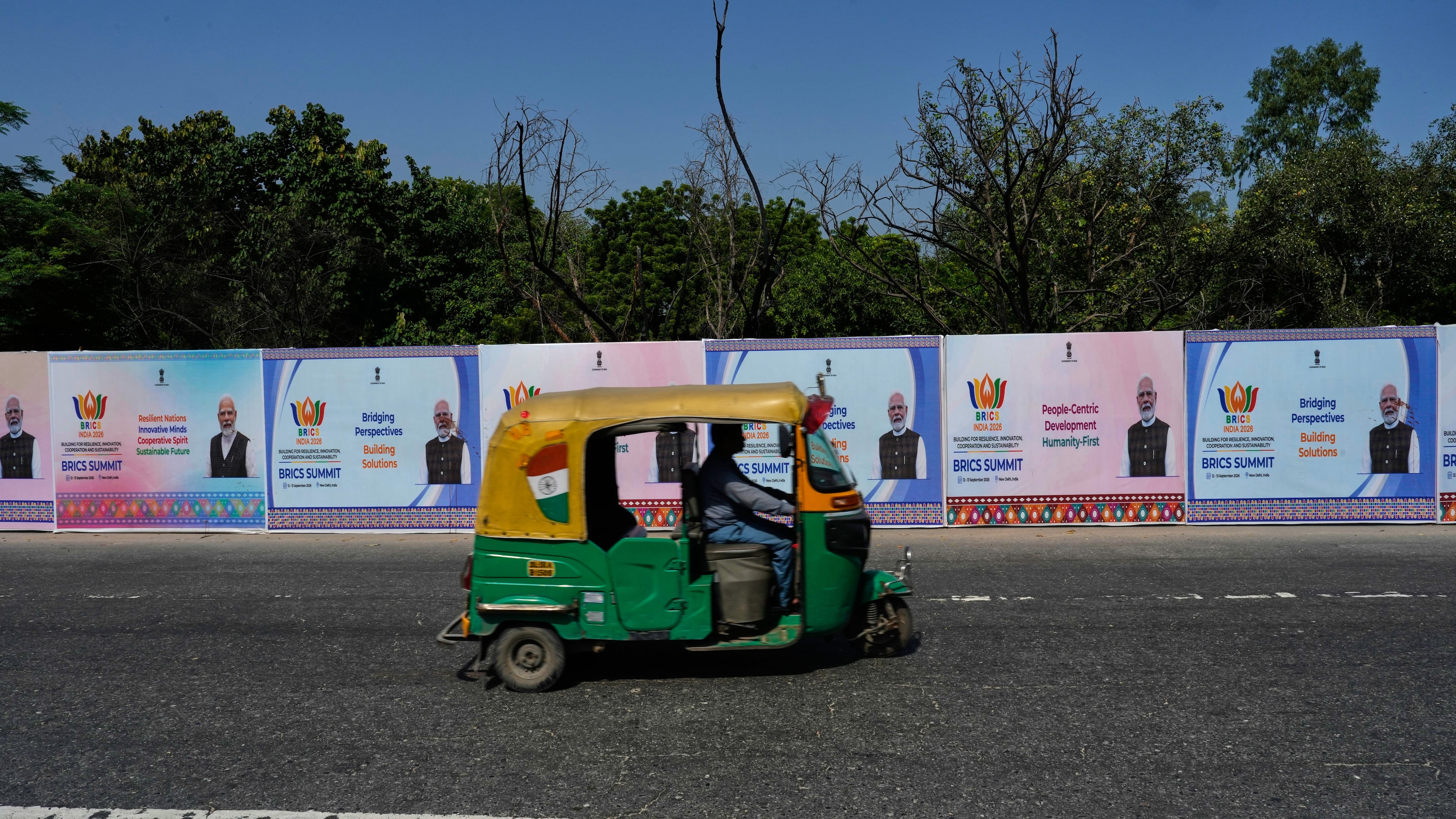 A three-wheeler drives past BRICS summit banners bearing an image of Indian Prime Minister Narendra Modi in New Delhi, India, Thursday, Sept. 10, 2026. (AP Photo/Manish Swarup)