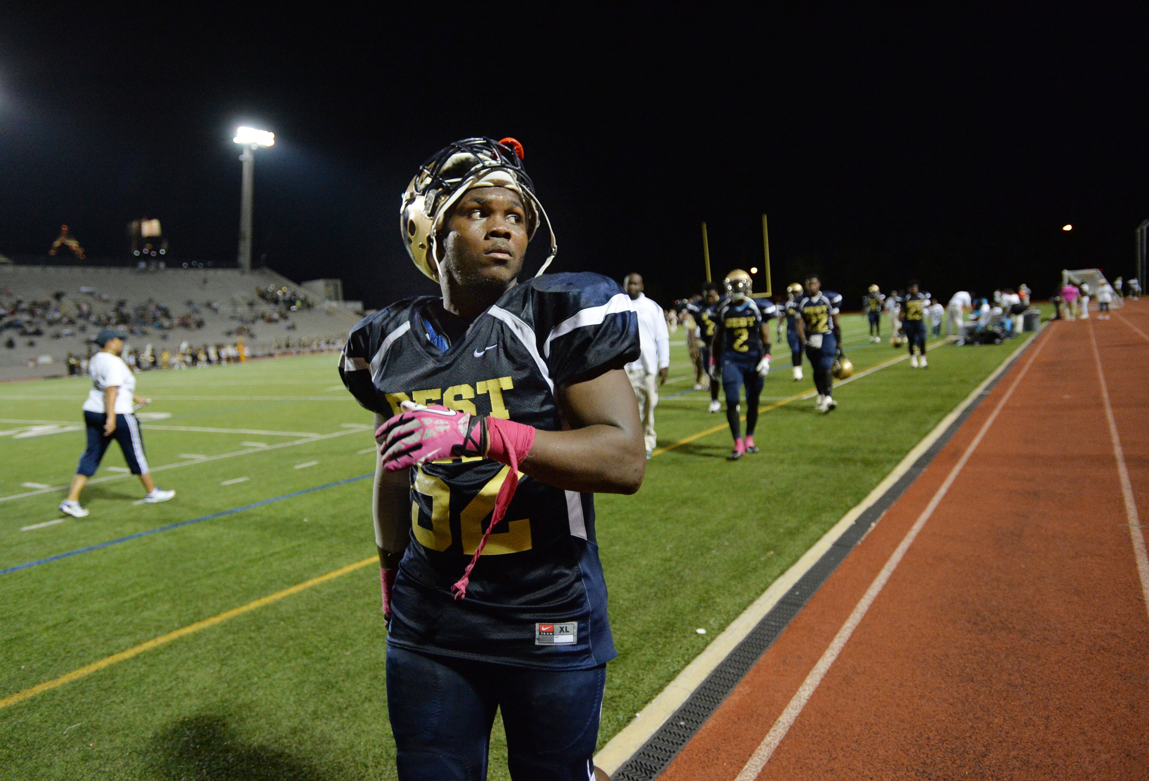 Darius Marshall, 18, looks to the football stand to check if his sister Ashley Roberson arrives for his senior night event in half time break during their game against the Wesleyan school at Grady High School stadium on Friday, October 10, 2014. HYOSUB SHIN / HSHIN@AJC.COM
