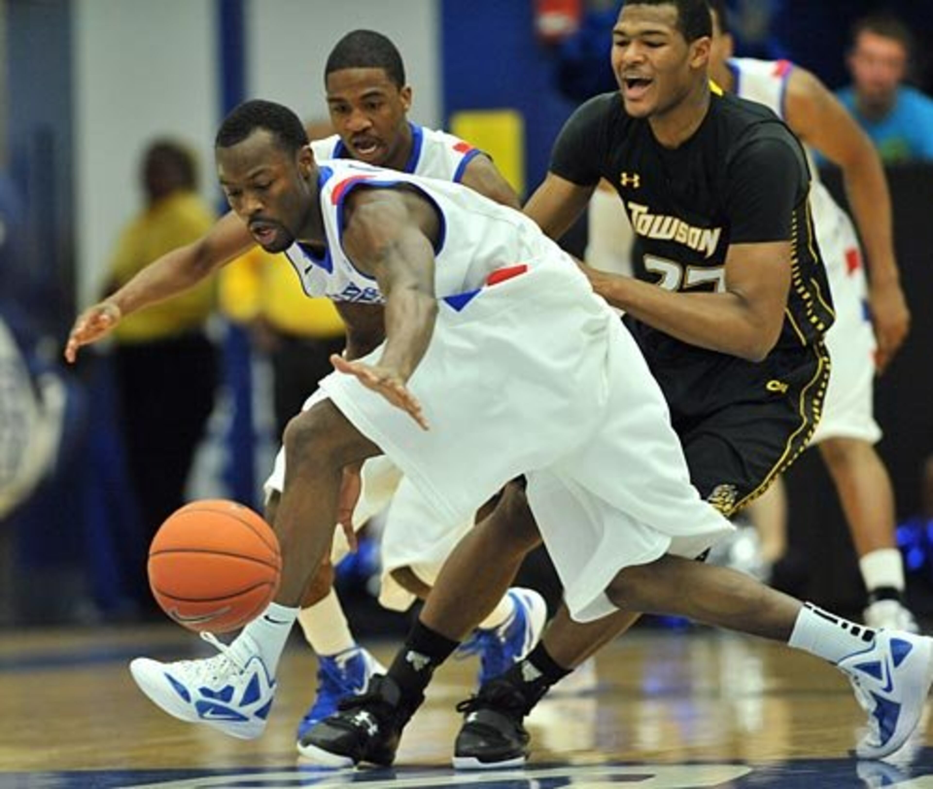 James Fields (foreground) wins the battle for a loose ball as Georgia State guard Devonta White and Towson forward Alex Giergen (right) pursue.