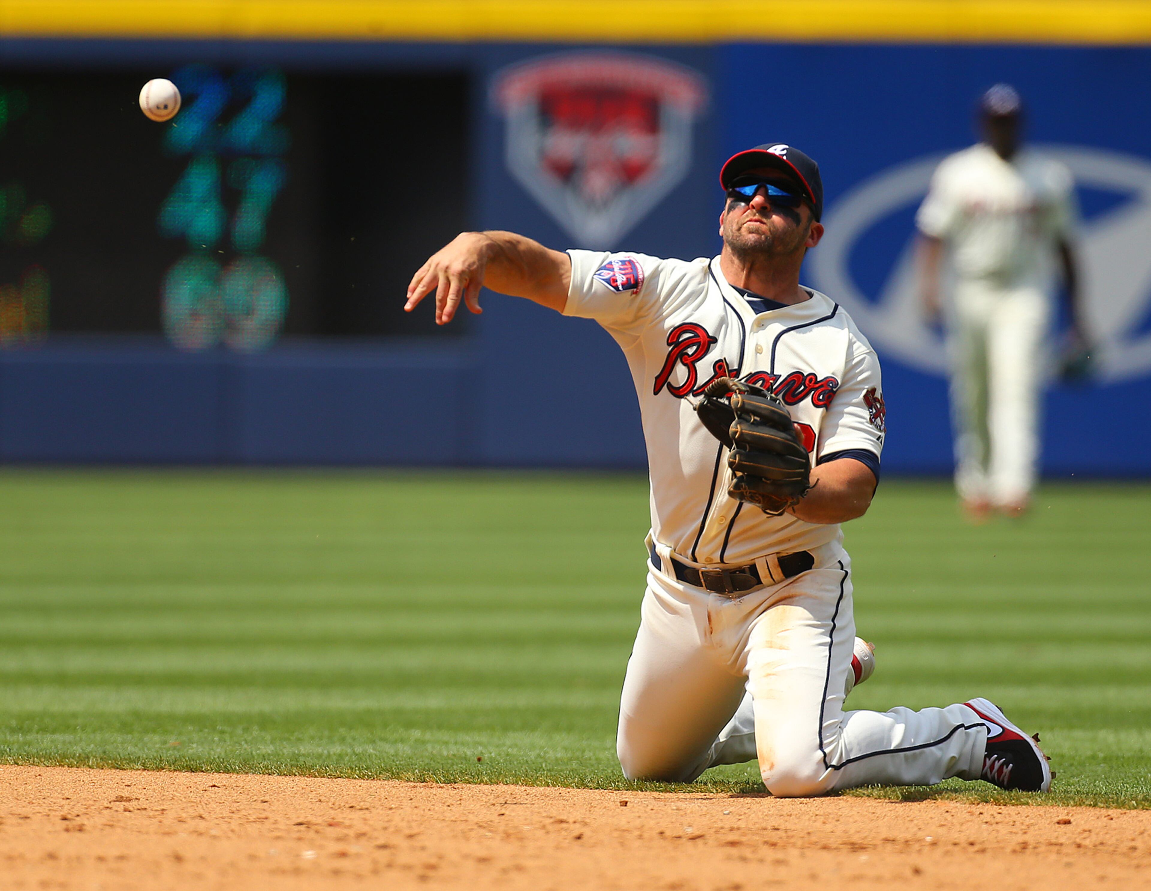 Dan Uggla makes a throw to first base from his knees for the out after making a play on a grounder by Reds Brandon Phillips during the 6th inning. CURTIS COMPTON / CCOMPTON@AJC.COM