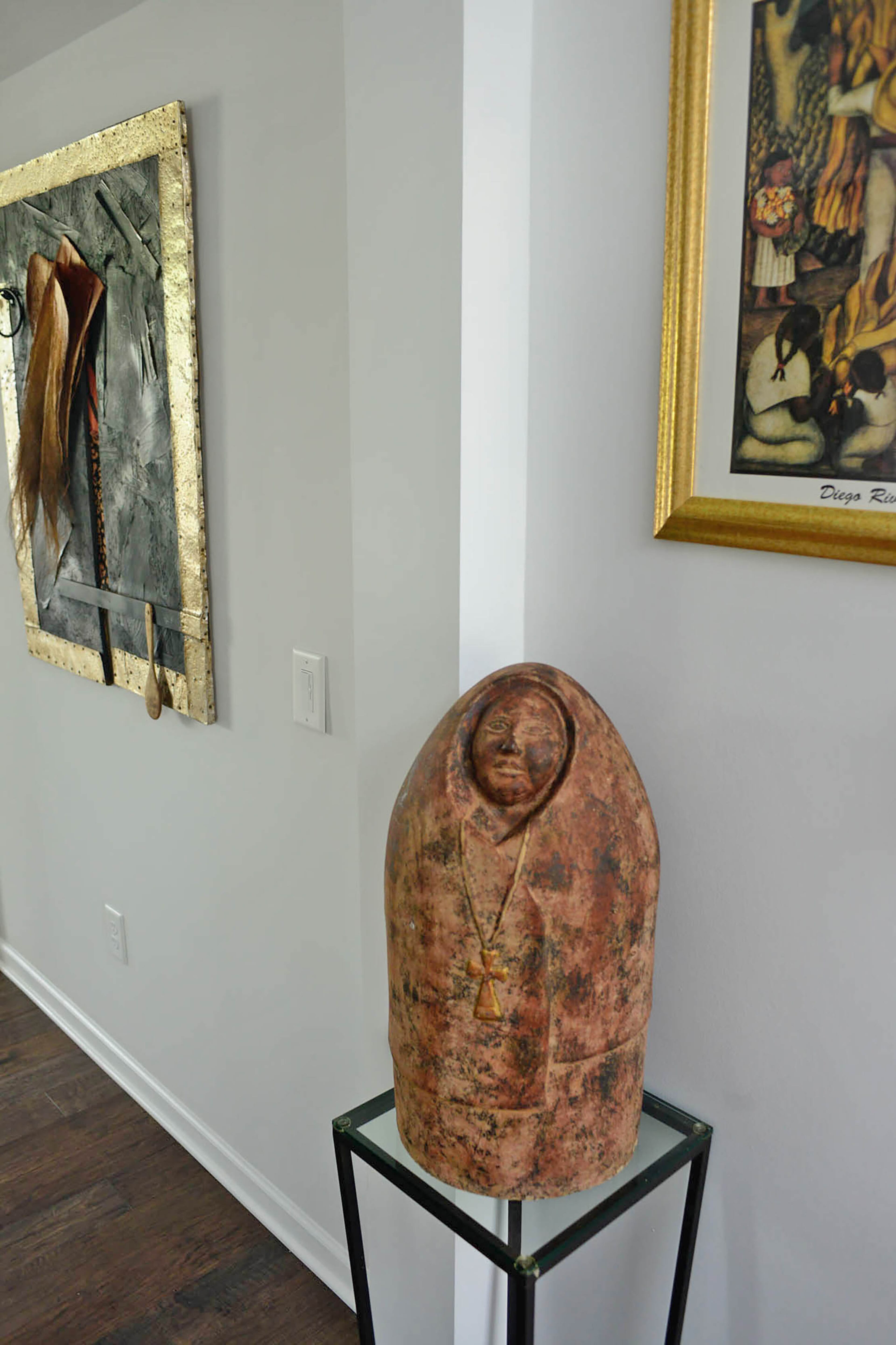 One of their exceptional pieces of art, a 2-foot-tall monk statue, sits on a glass and iron table in the hall.