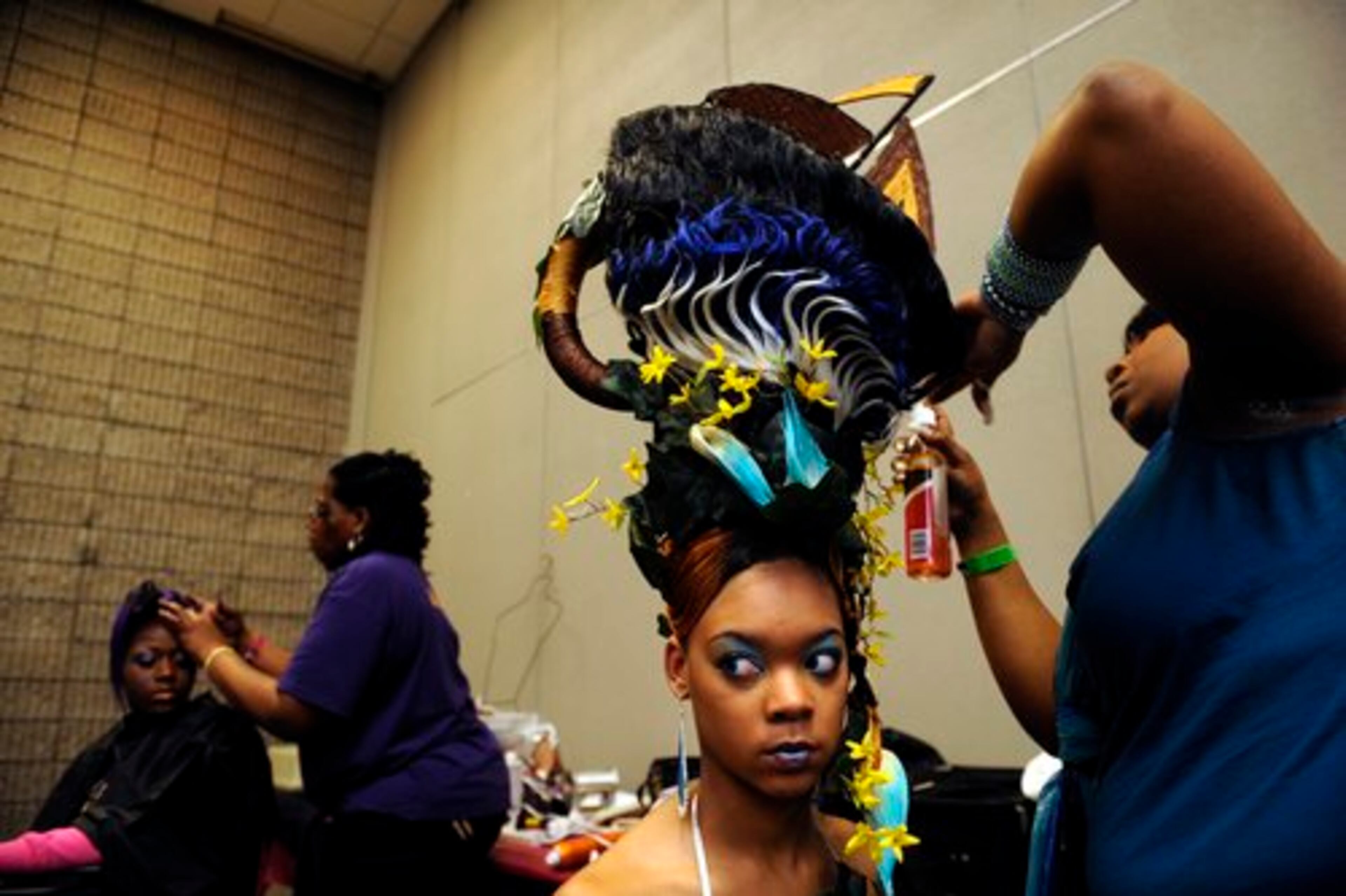 From left, Twyla Mays, 20, gets an oversized head piece shaped like a ship secured to her head by stylist Veronica Kimmons, 27, of Holly Springs, Miss., to complete her goddess of the sea fantasy look.