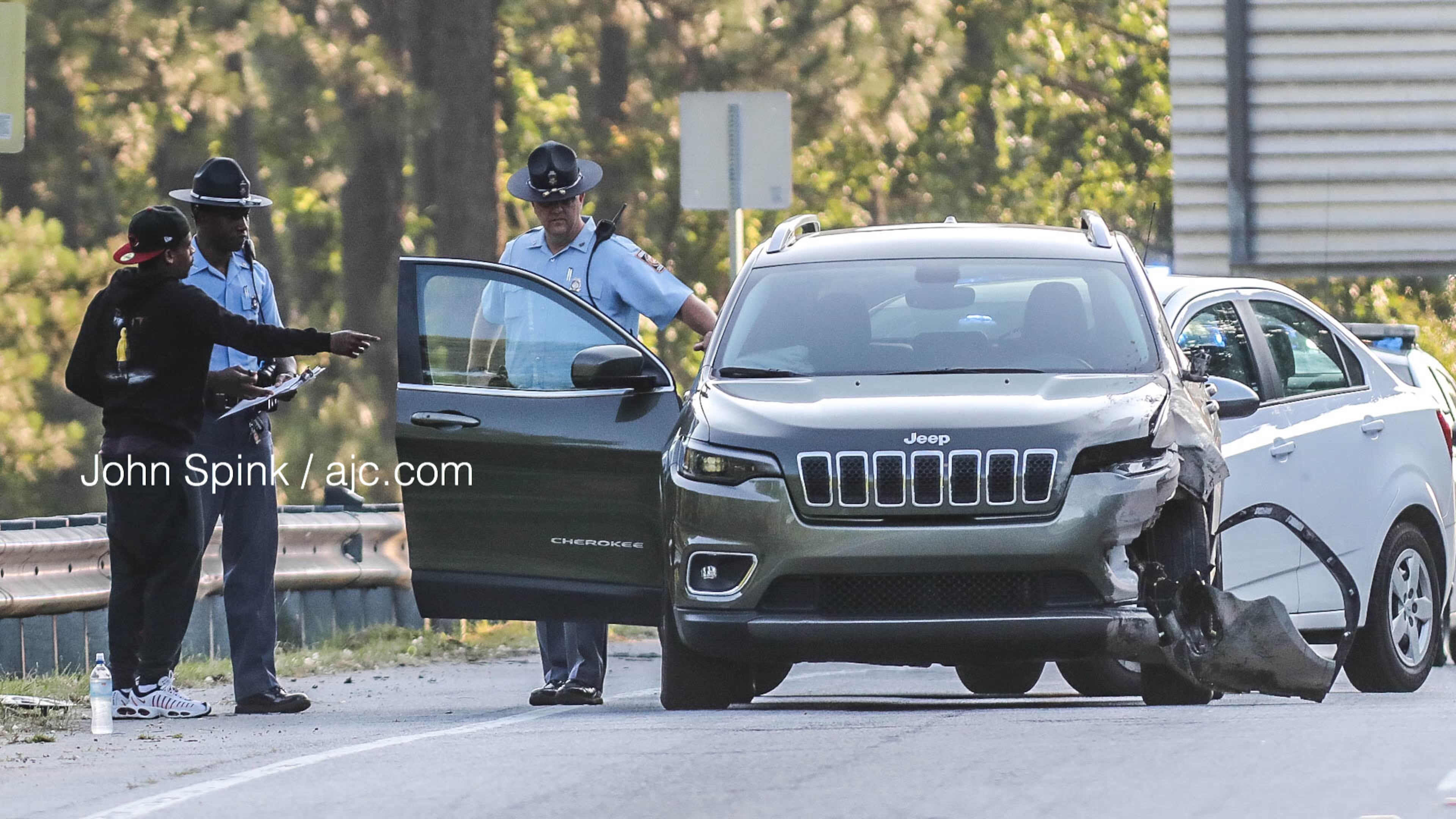 State troopers speak with a driver on the scene of a pedestrian crash on the I-85 South ramp to Jonesboro Road on Friday morning.