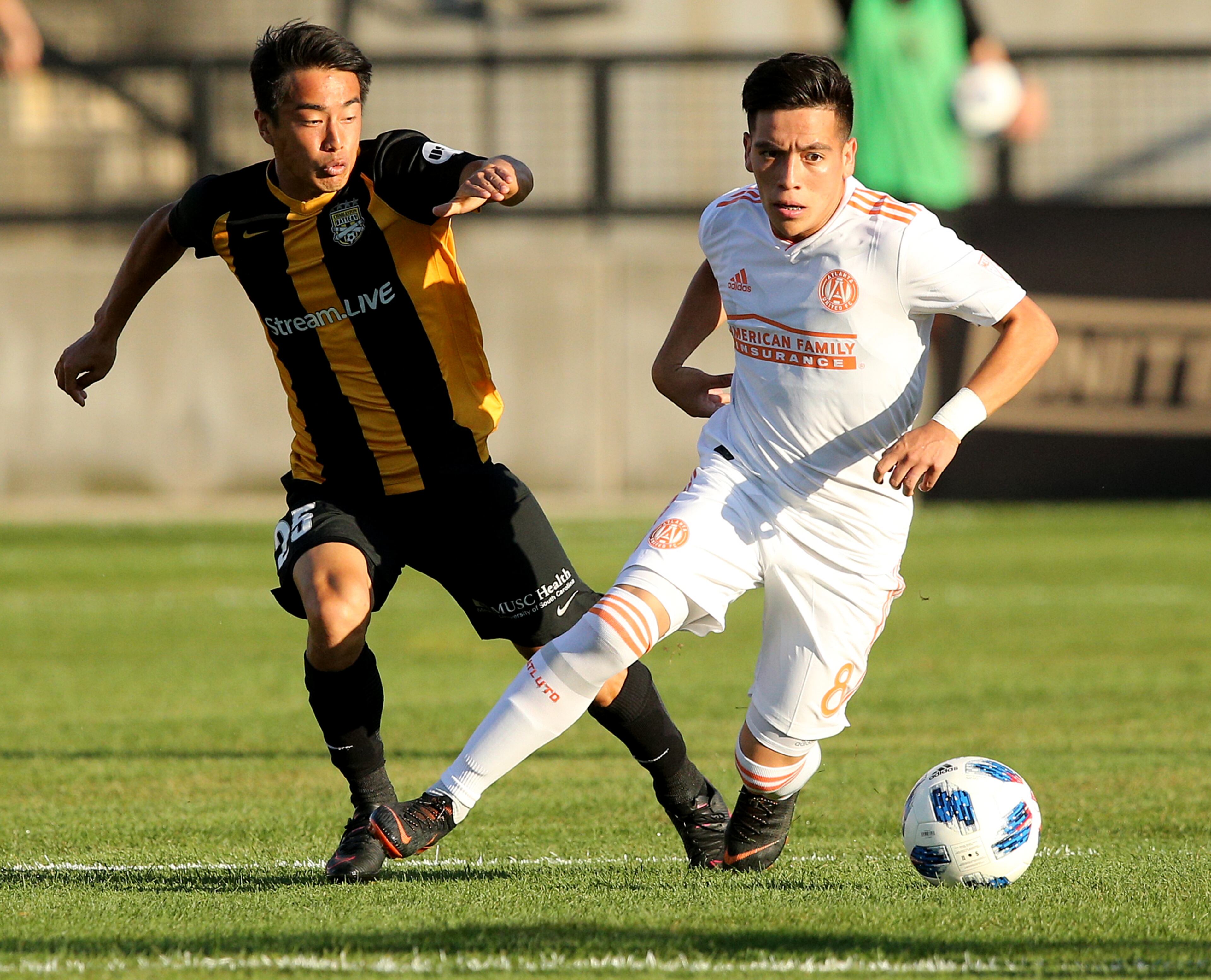 June 6, 2018 Kennesaw: Atlanta United midfielder Ezequiel Barco drives the pitch against Charleston Battery midfielder Kotaro Higashi during the first half in a U.S. Open Cup match on Wednesday, June 6, 2018, in Kennesaw. Curtis Compton/ccompton@ajc.com